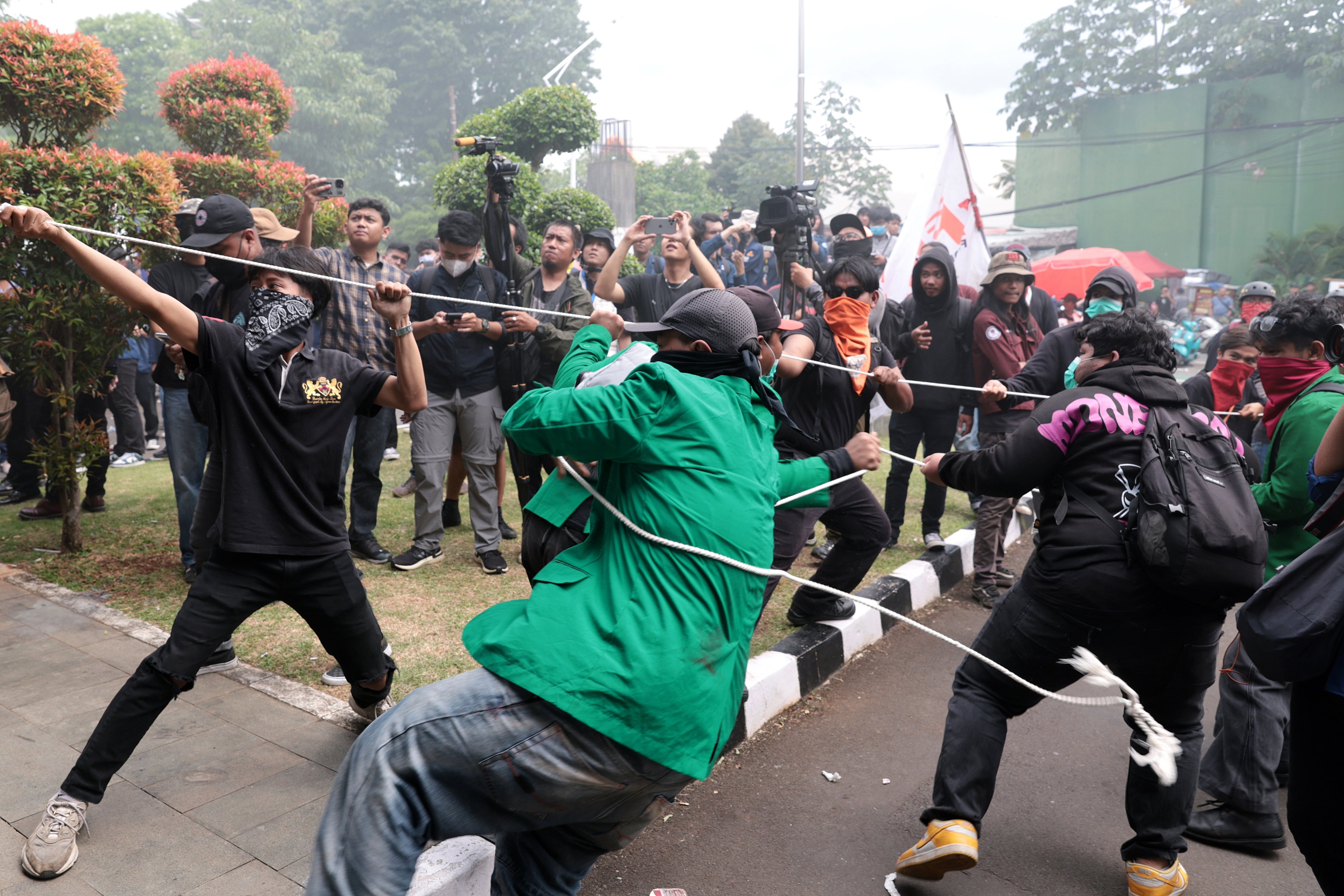 Indonesian students and activists try to tear down a gate in front of the parliament building in Jakarta during a protest against the revision of the country’s military law  on March 20, 2025. Photo: EPA-EFE