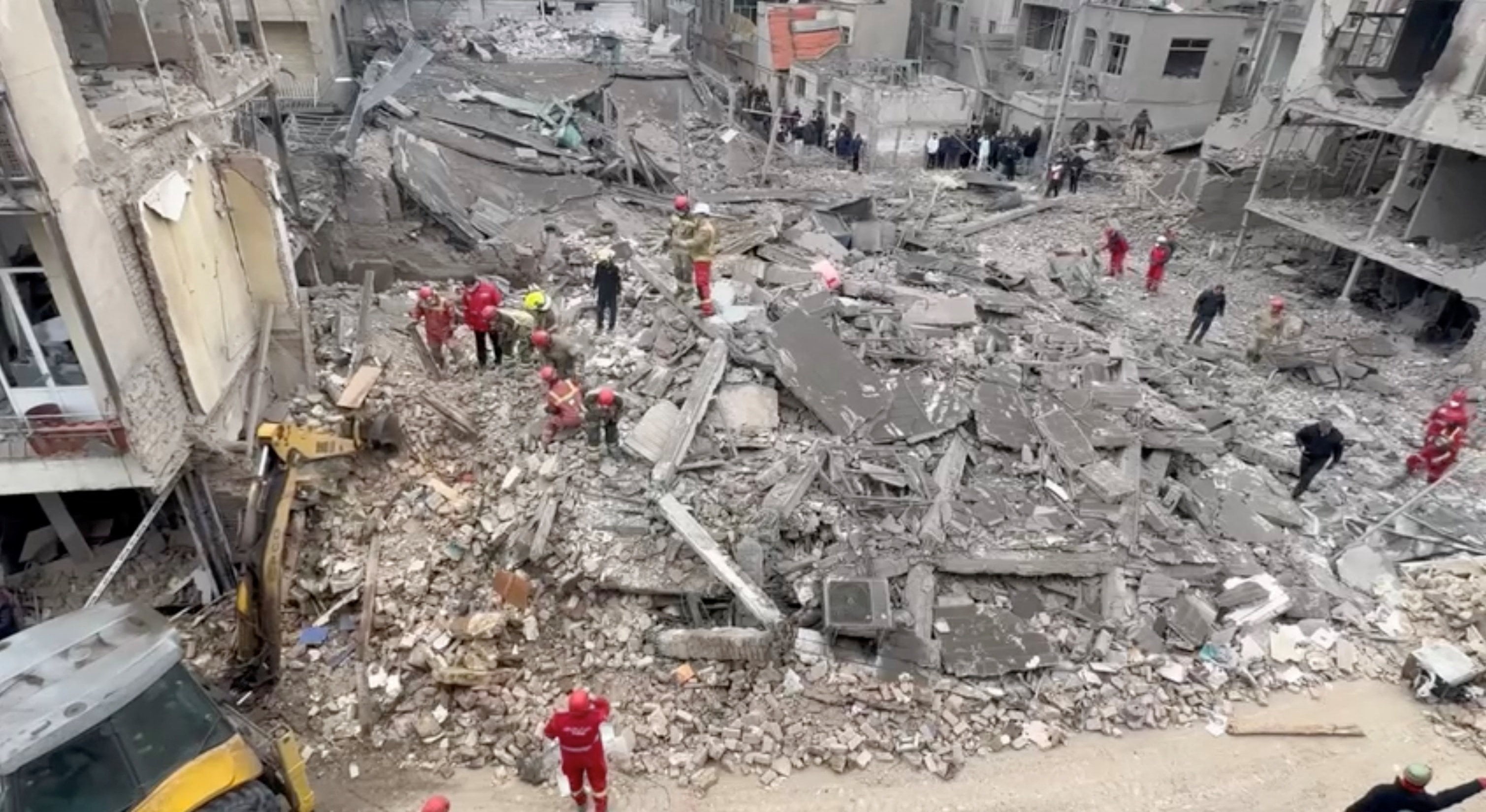 Iranian Red Crescent aid workers and firefighters work at a residential site damaged by strikes in Tehran’s Javadiyeh district on Saturday. Photo: Iranian Red Crescent Society via Reuters