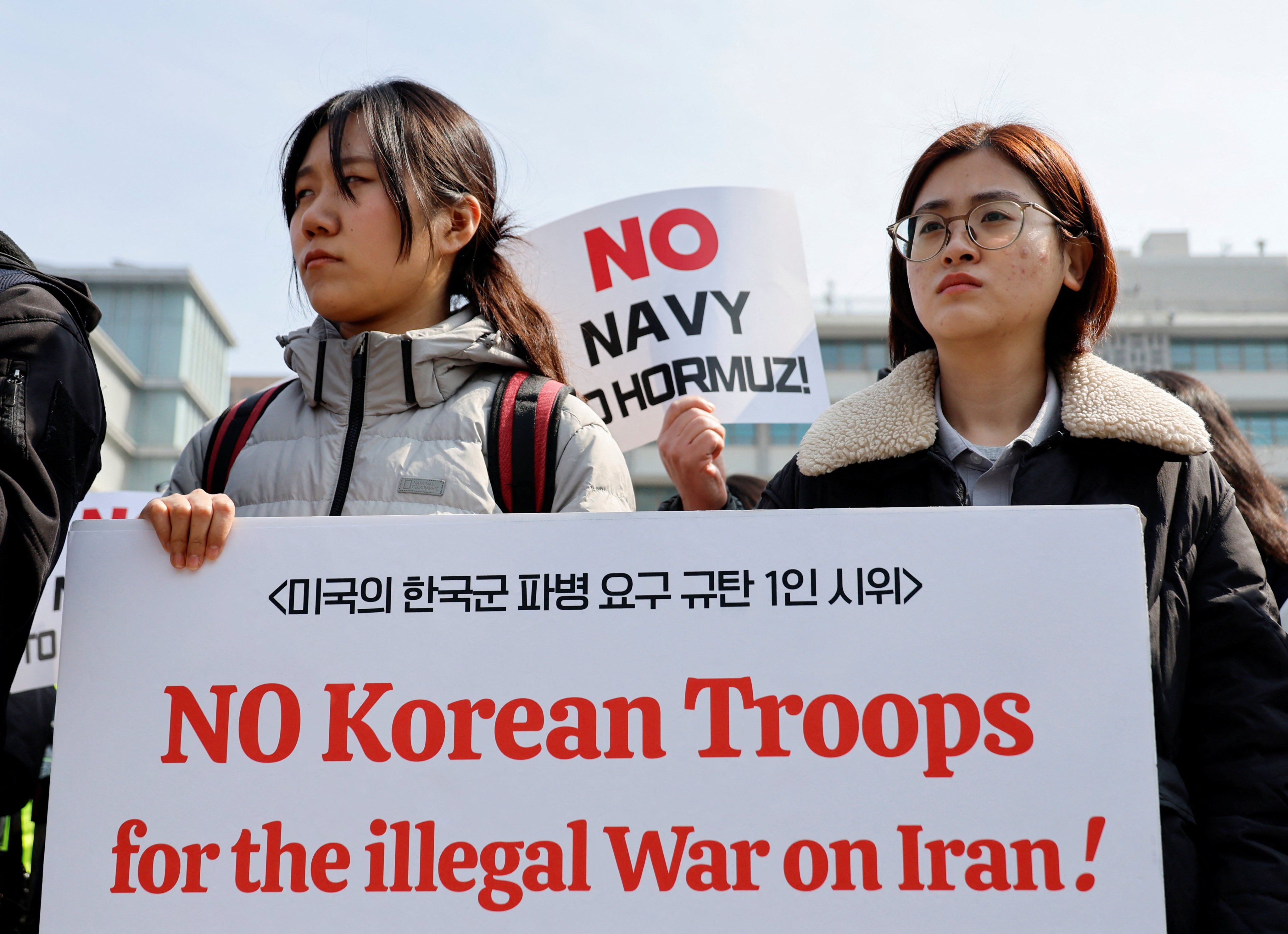 Activists hold placards during a rally against the US demand for South Korea to deploy troops to the Strait of Hormuz, outside the US embassy in Seoul on Monday. Photo: Reuters