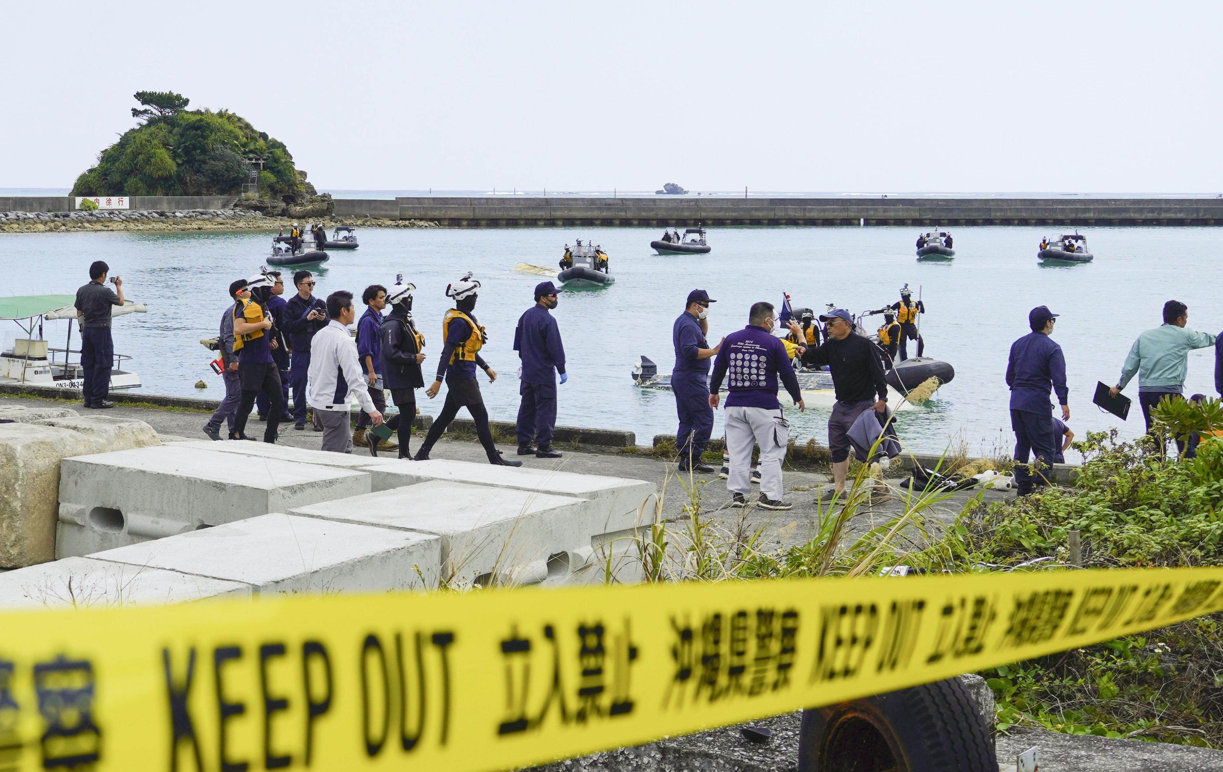 Japan Coast Guard officials prepare to to search at a port in Henoko after two boats capsize on Monday. Photo: Kyodo