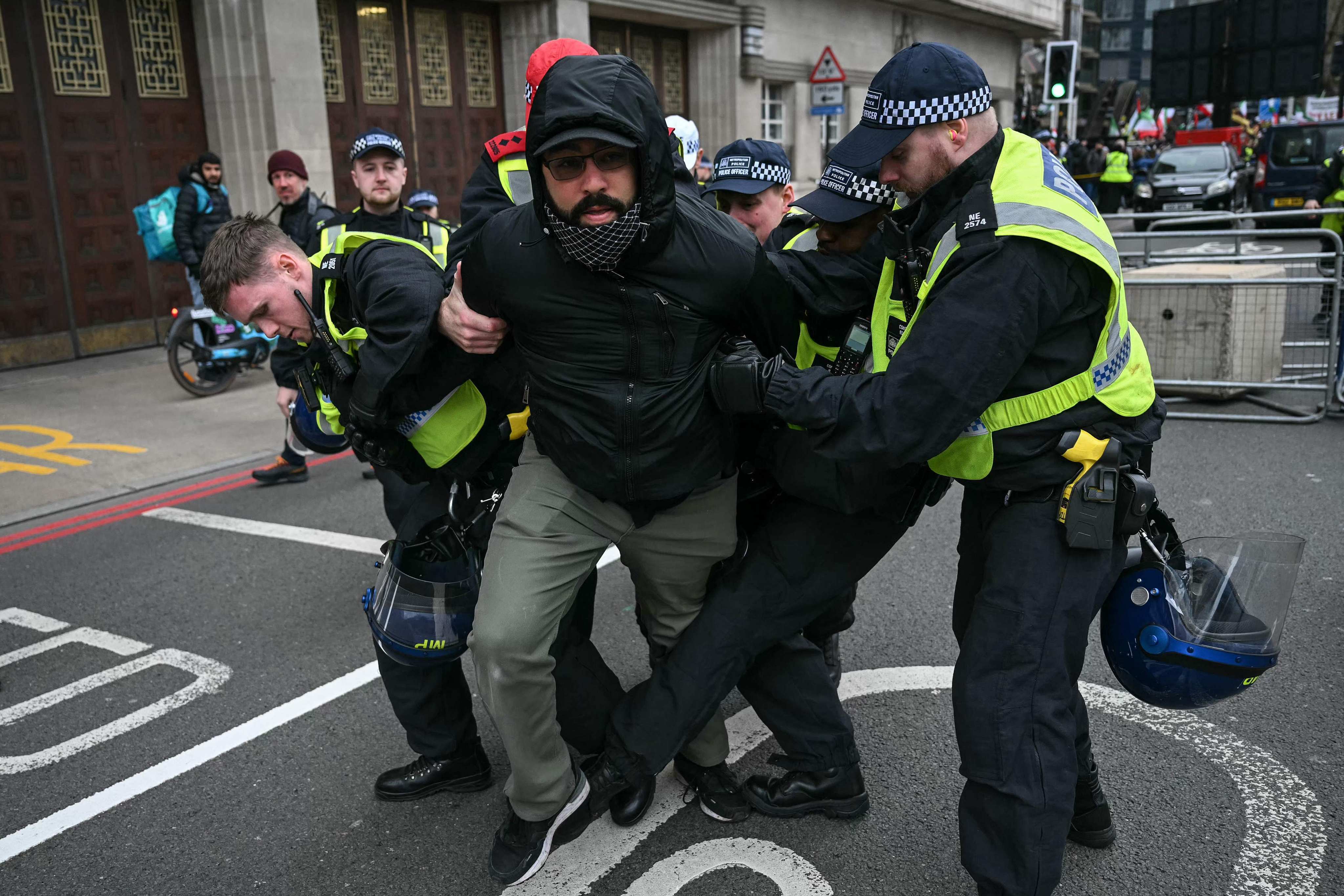 Police arrest a protester for not removing a face covering during a protest held by pro-Palestinian group Al-Quds in central London on Sunday. Photo: AFP