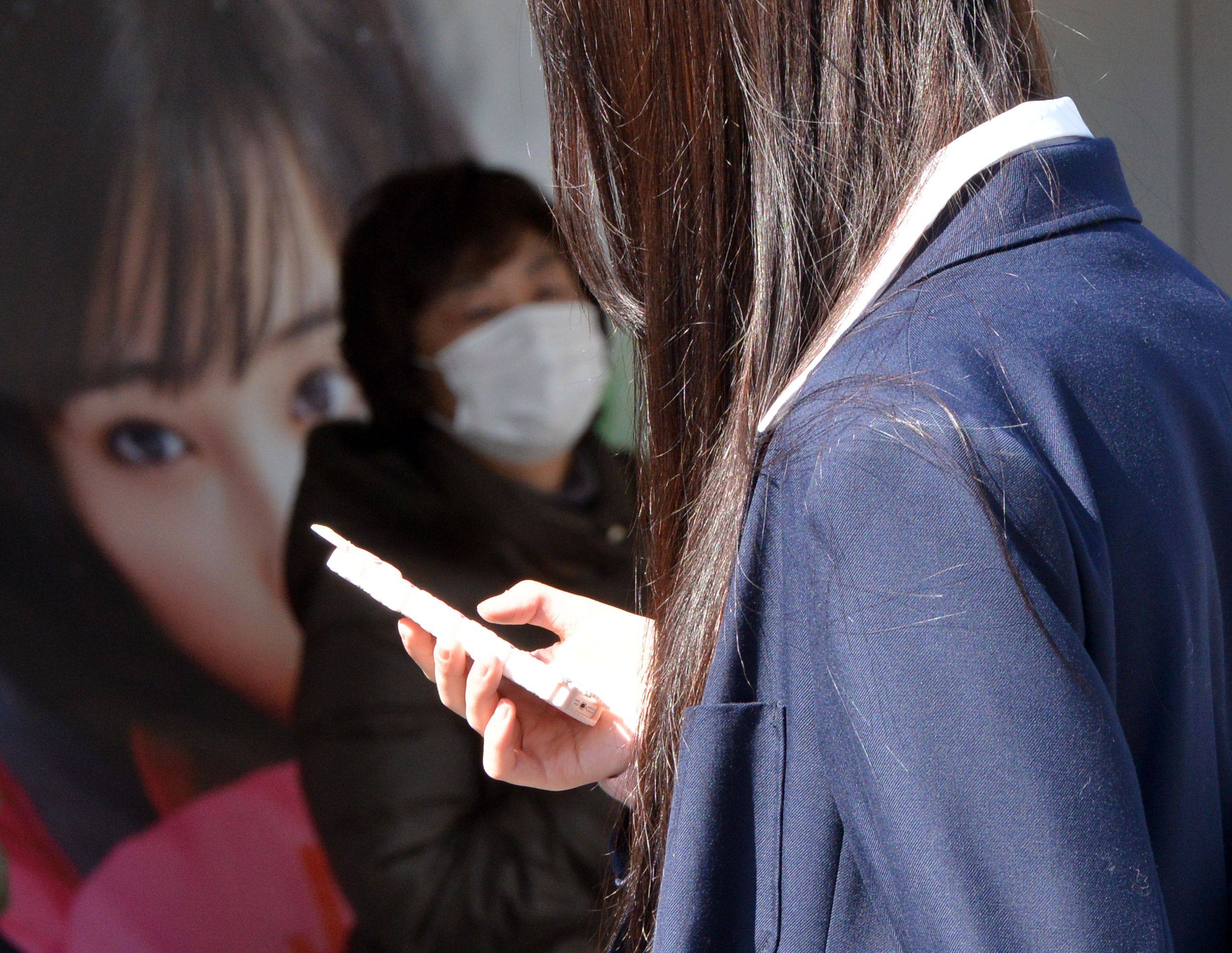 A high school girl uses her smartphone in Tokyo, Japan. Photo: AFP