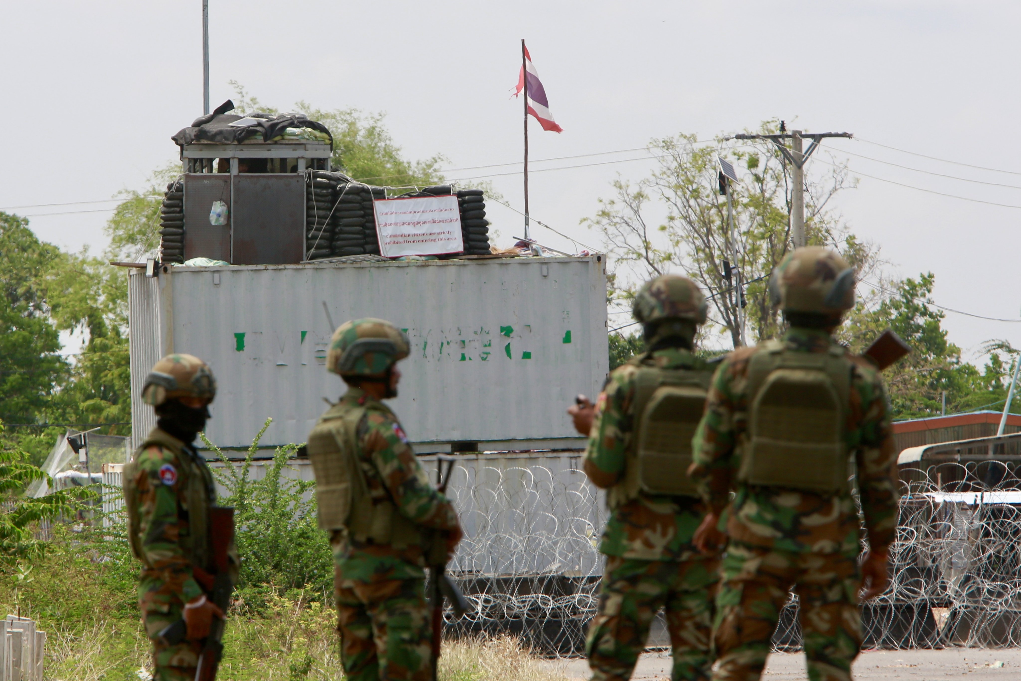 Cambodian soldiers stand guard in front of containers and barbed wires put up by Thailand in Banteay Meanchey province, Cambodia, on Friday. Photo:  EPA