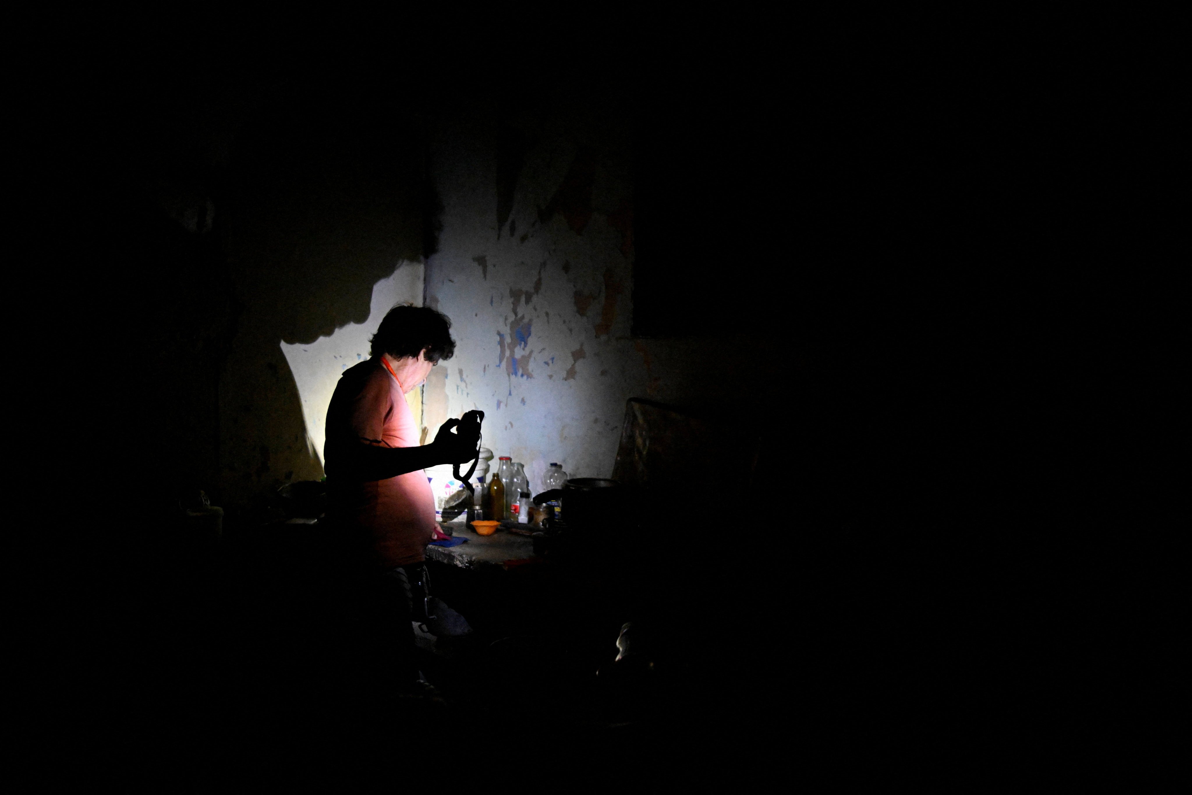 A man uses a flashlight after Cuba’s national electric grid collapsed. Photo: Reuters