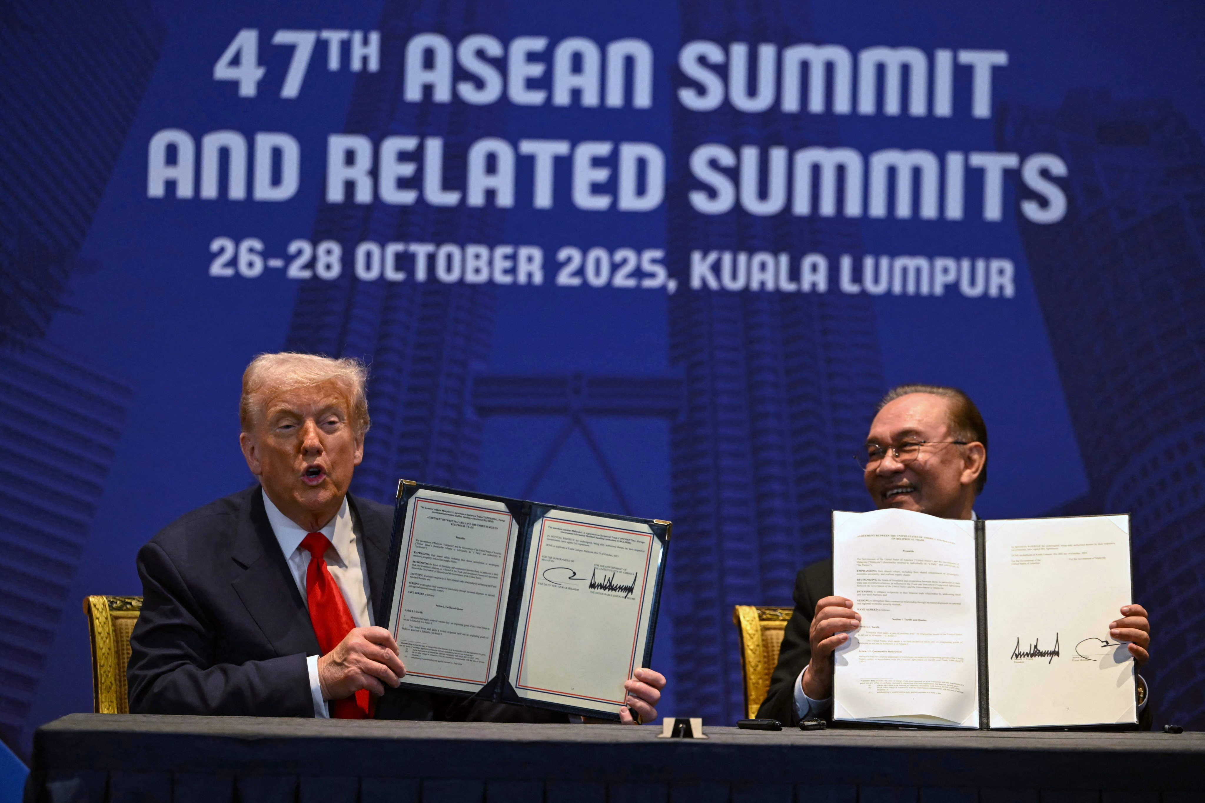 US President Donald Trump (left) and Malaysia’s Prime Minister Anwar Ibrahim hold up signed documents on a trade deal in Kuala Lumpur on October 26, 2025. Photo: AFP