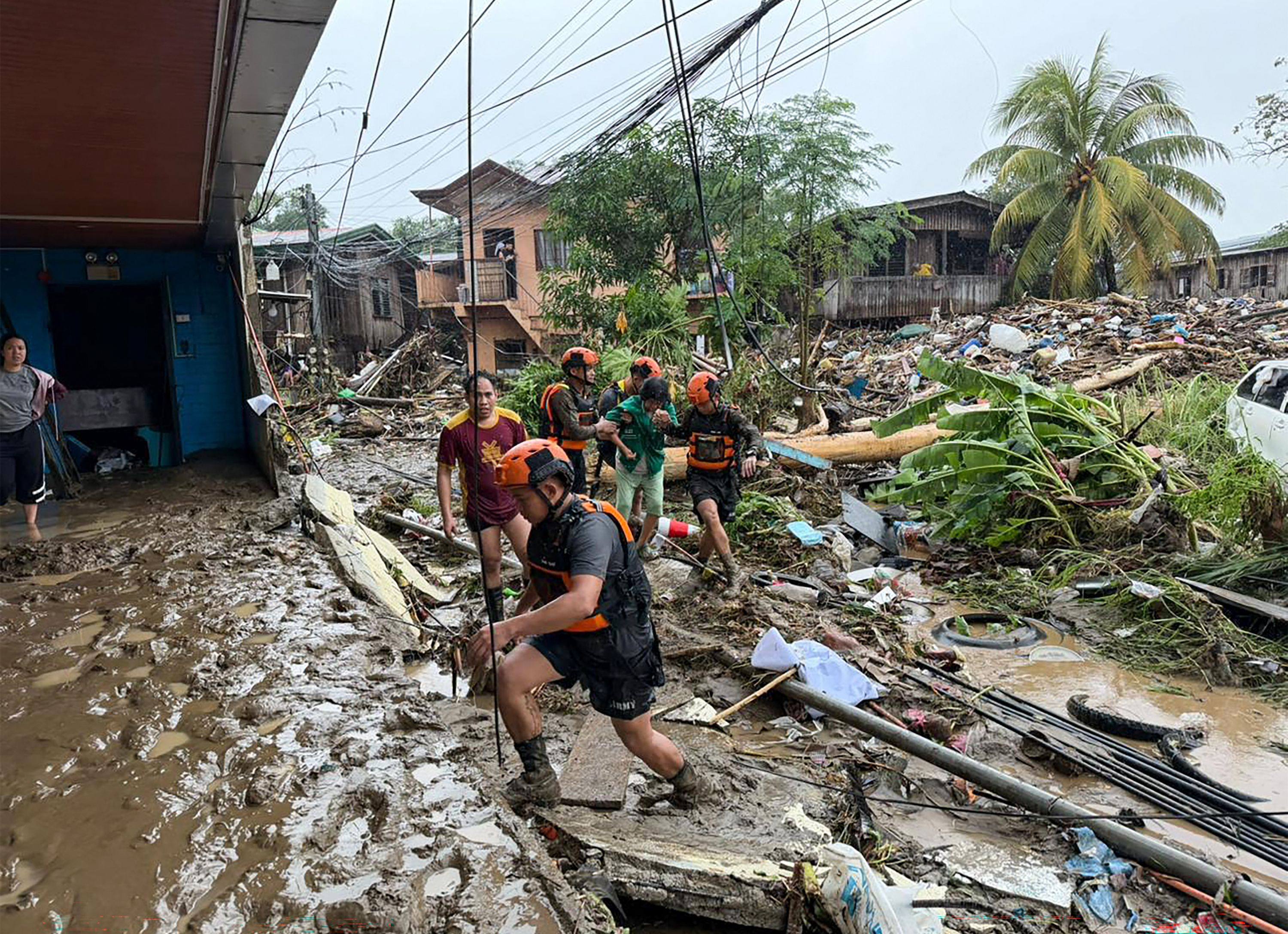 Rescuers evacuate a woman after Tropical Storm Penha hit the area in Iligan, in the Philippines’ Lanao del Norte province, on February 6. Photo: AFP
