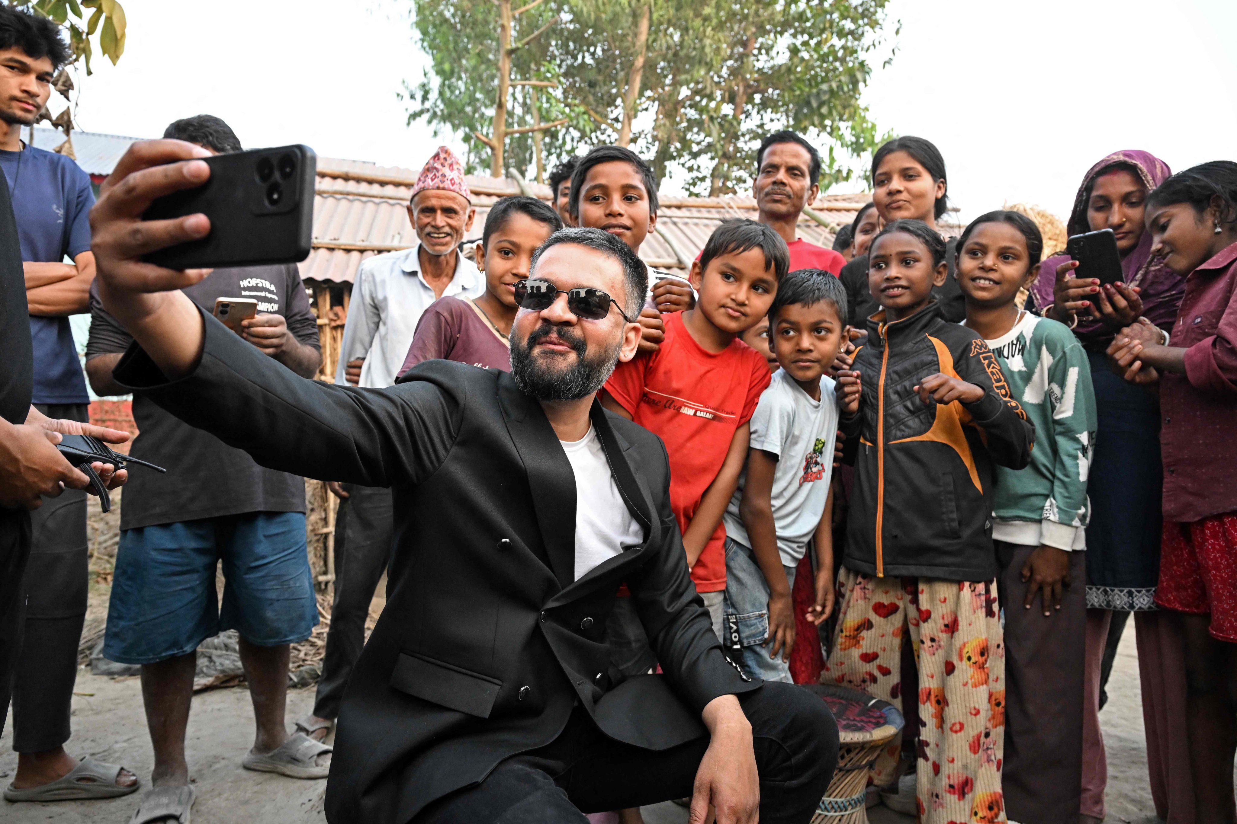 Balendra Shah of the Rastriya Swatantra Party takes a selfie with children and supporters during a door-to-door election campaign on February 16. Photo: AFP
