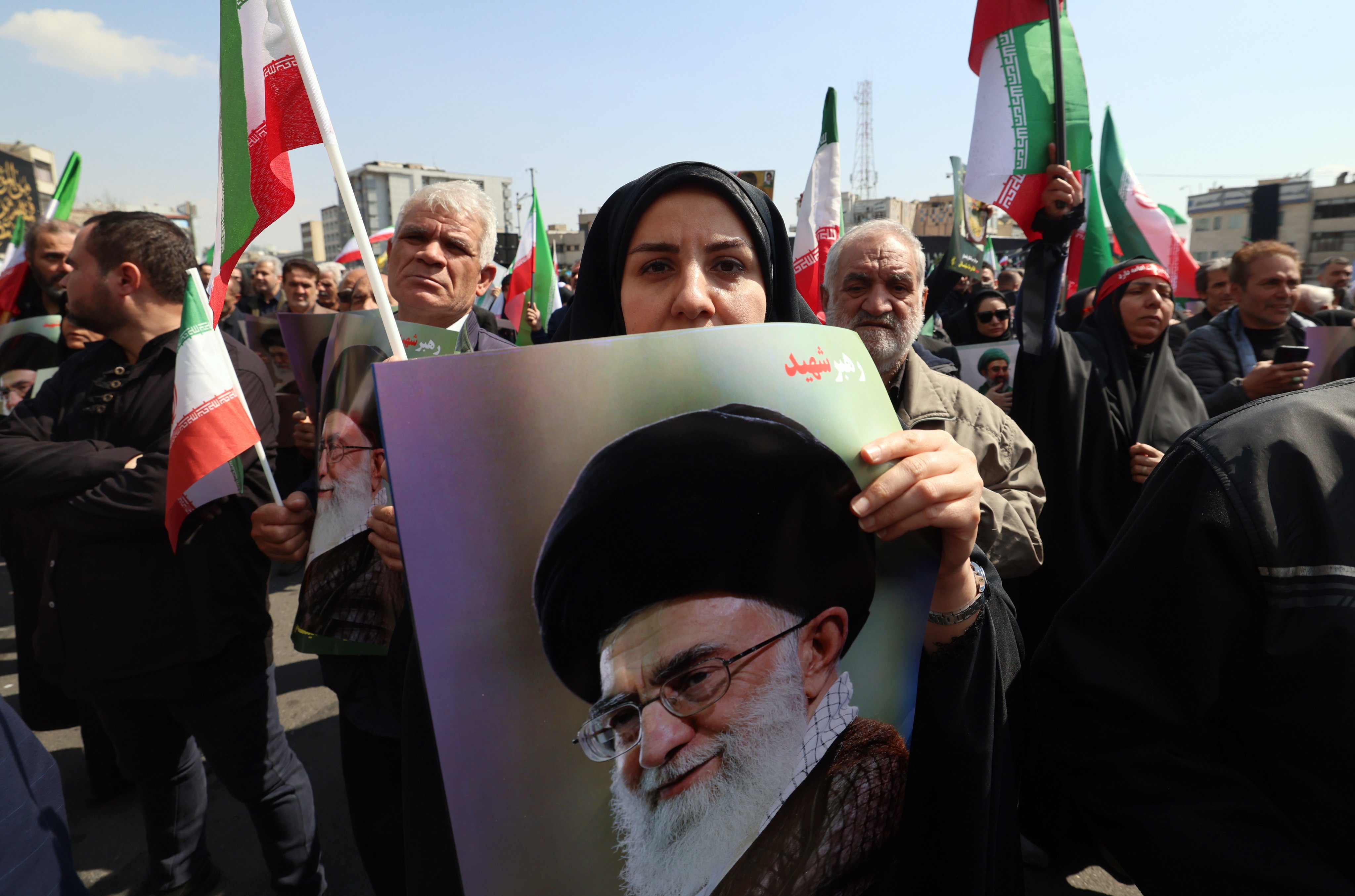 Mourners hold posters of Ayatollah Ali Khamenei, Iran’s late supreme leader, as they take part in a funeral procession for other war dead, in Tehran on Wednesday. Photo: EPA