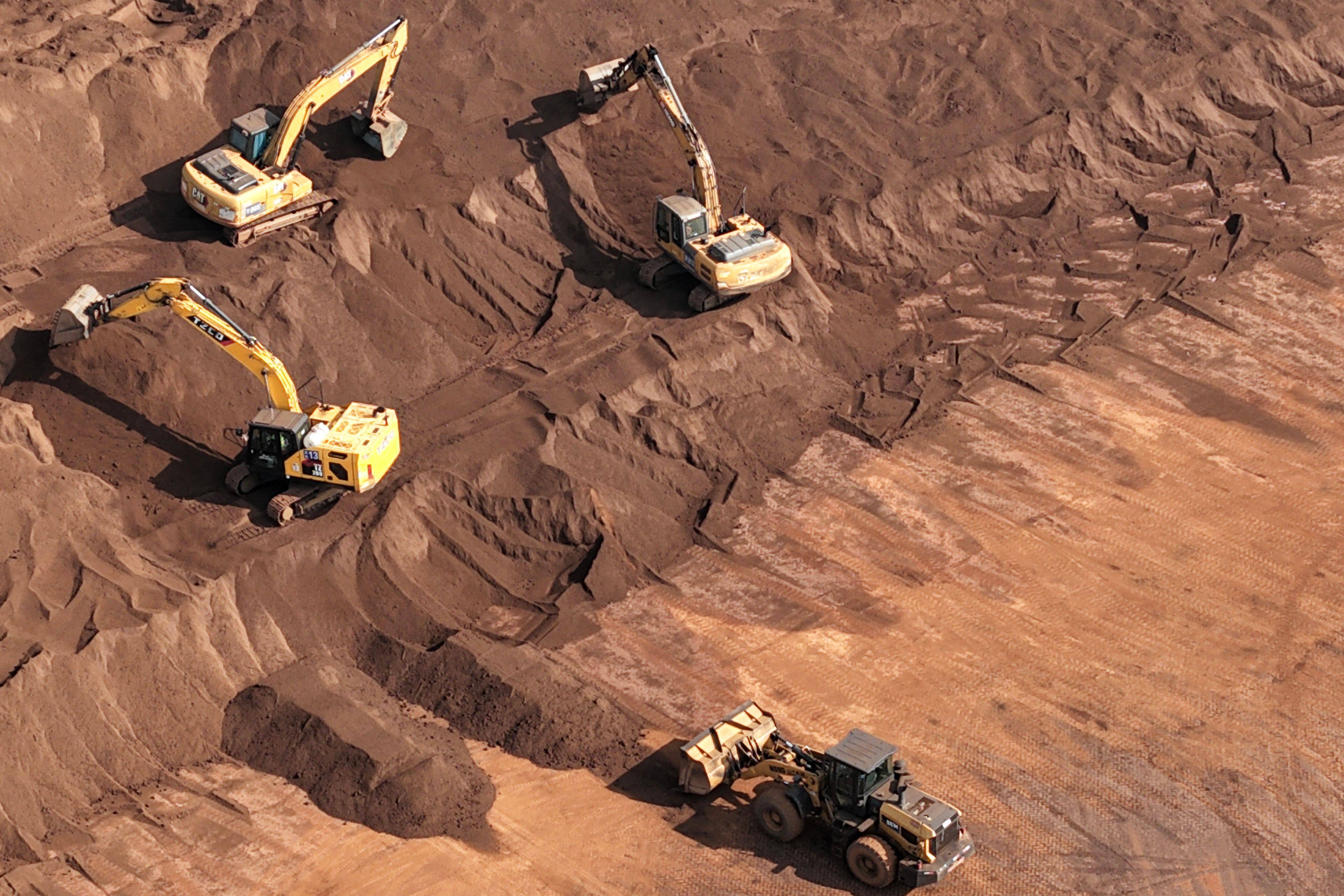 Workers operate machinery at an iron ore stockyard at the port in Rugao, in eastern China’s Jiangsu province. Photo: AFP