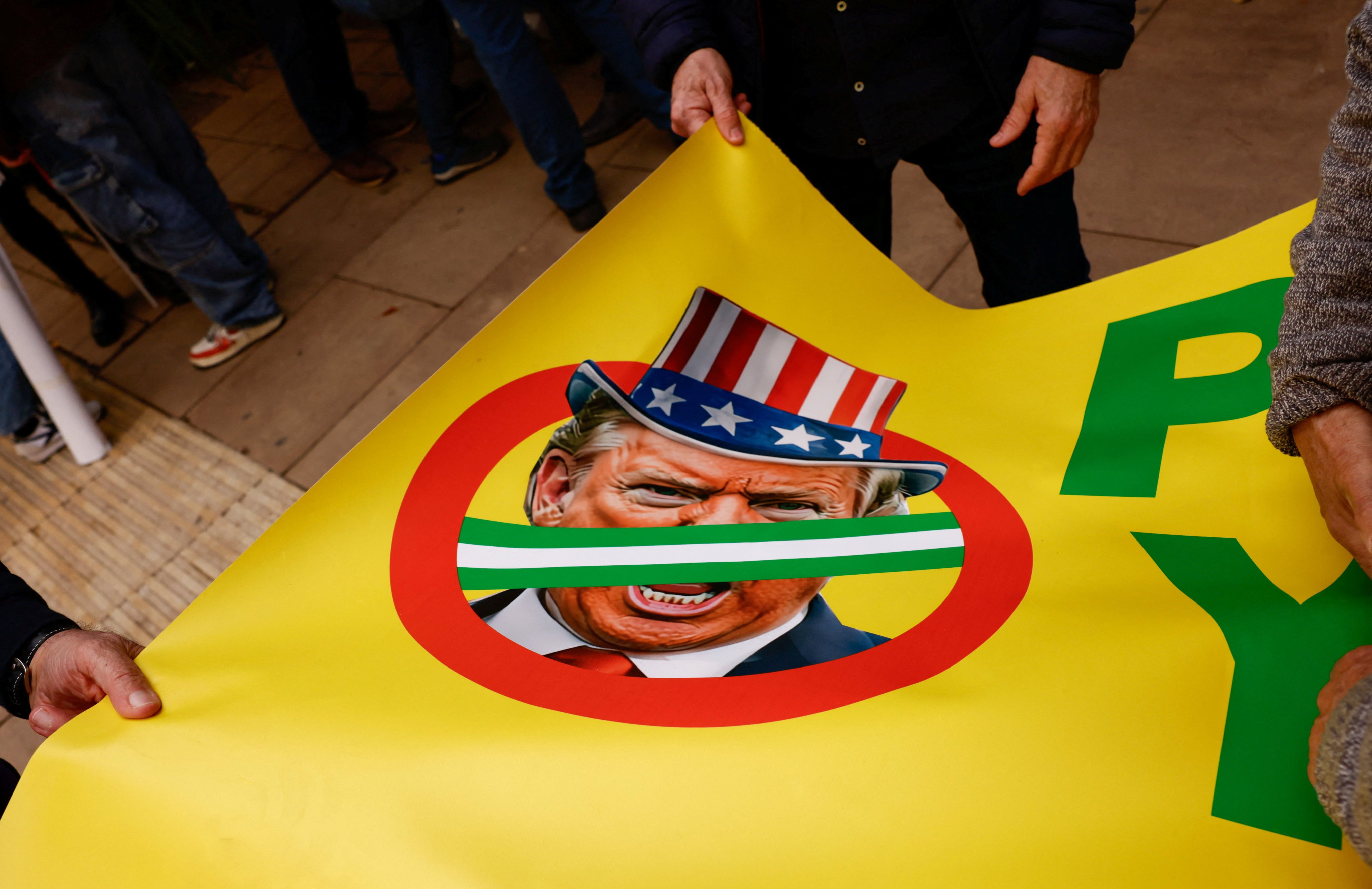 People hold a banner with an image of US President Donald Trump during an anti-war protest in Malaga, Spain, on March 7. Photo: Reuters