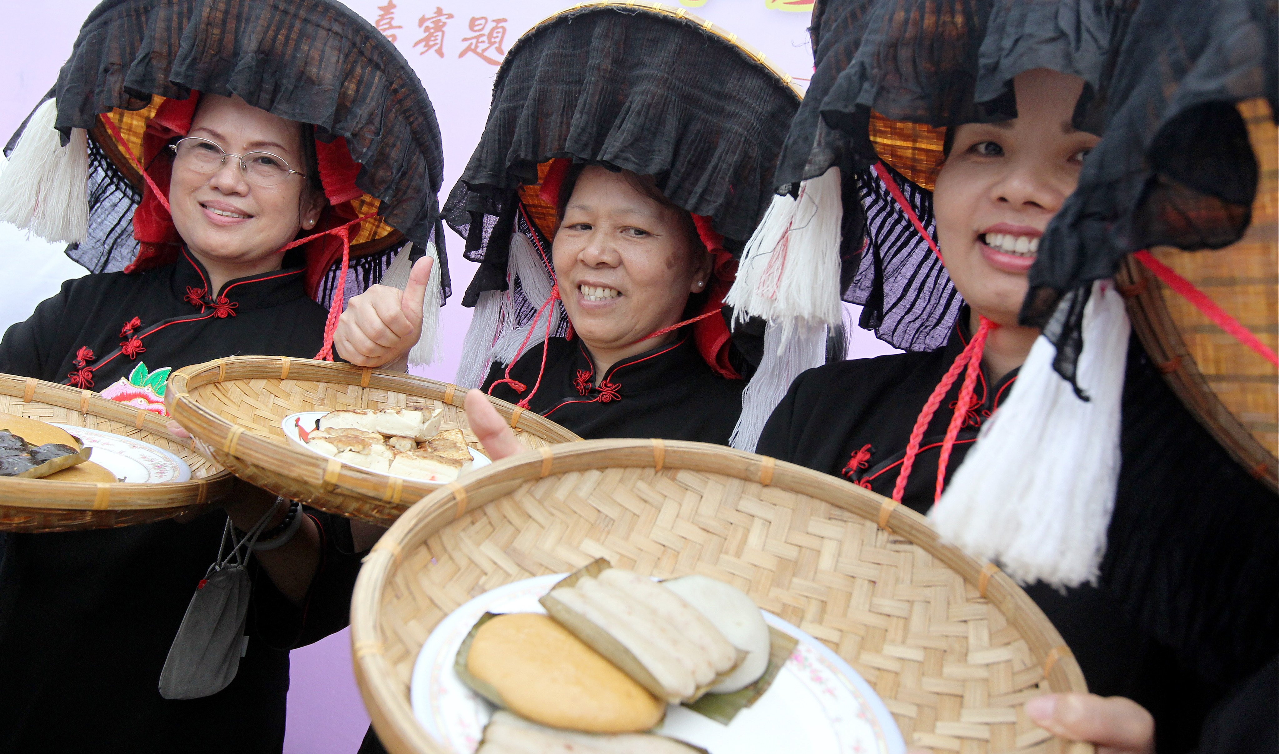 Hakka women dressed in traditional costumes hold trays of Hakka foods during the opening ceremony of the Hakkien Food Carnival at Tai Po Lam Tsuen, Hong Kong, in July 2013. Photo: SCMP