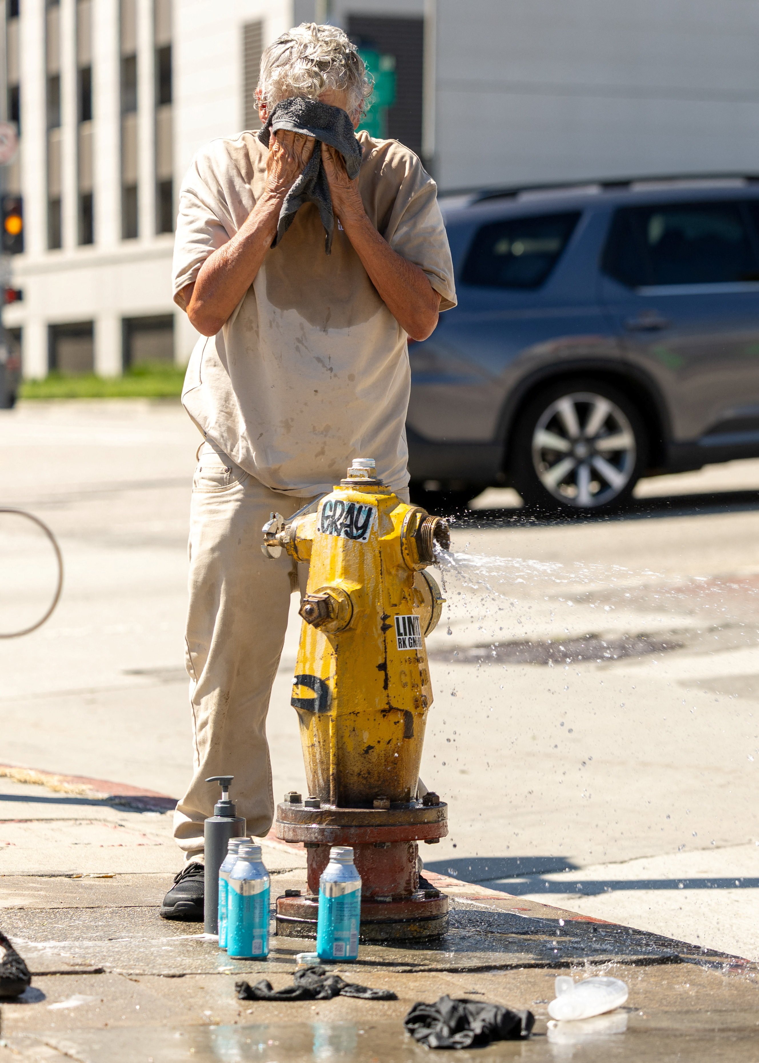 An unhoused person cools off using a fire hydrant as a heatwave engulfs southern California in Los Angeles. Photo: Reuters