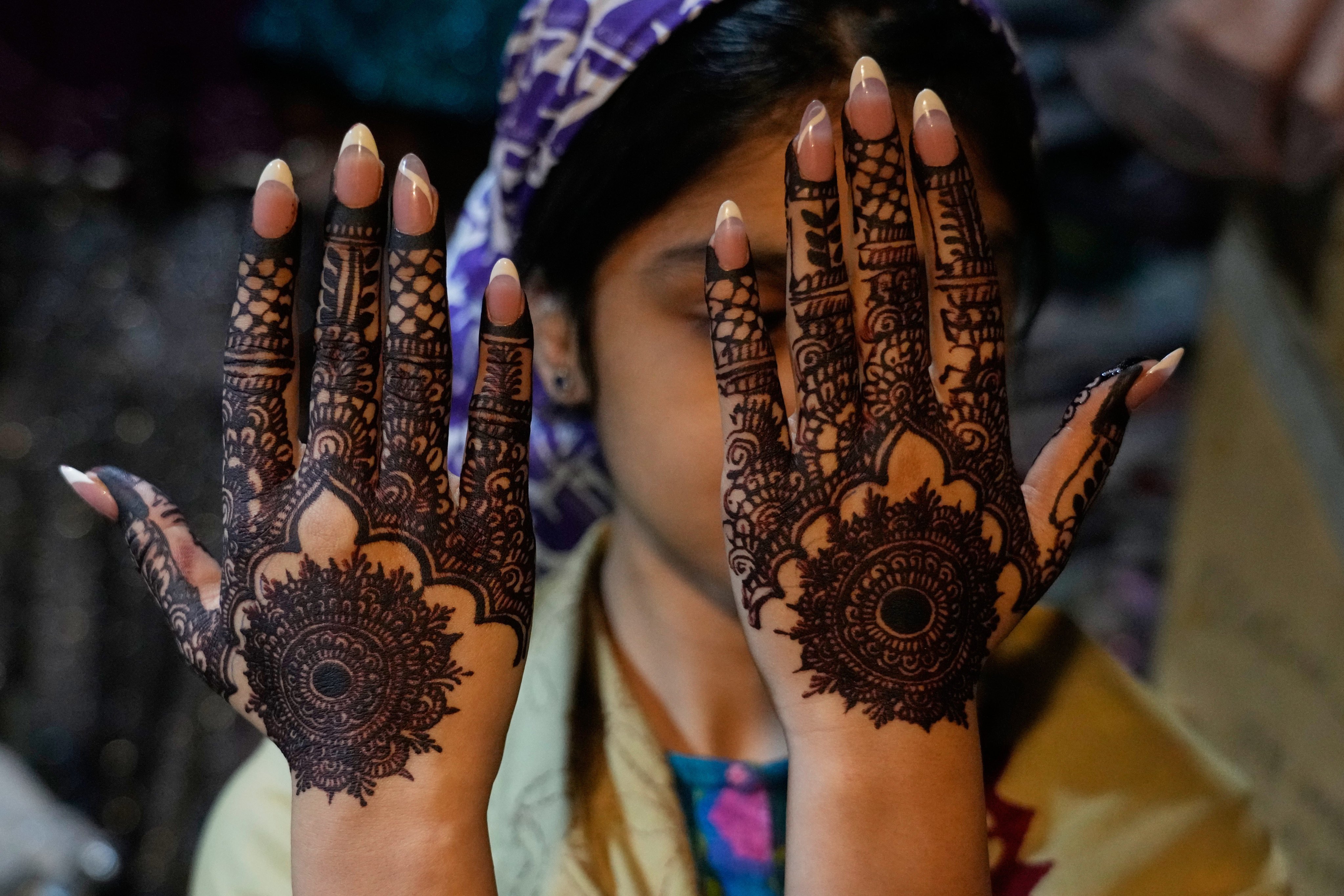 A woman shows her hands decorated with traditional henna designs in preparation for the upcoming Eid al-Fitr celebrations in Lahore, Pakistan. Photo: AP