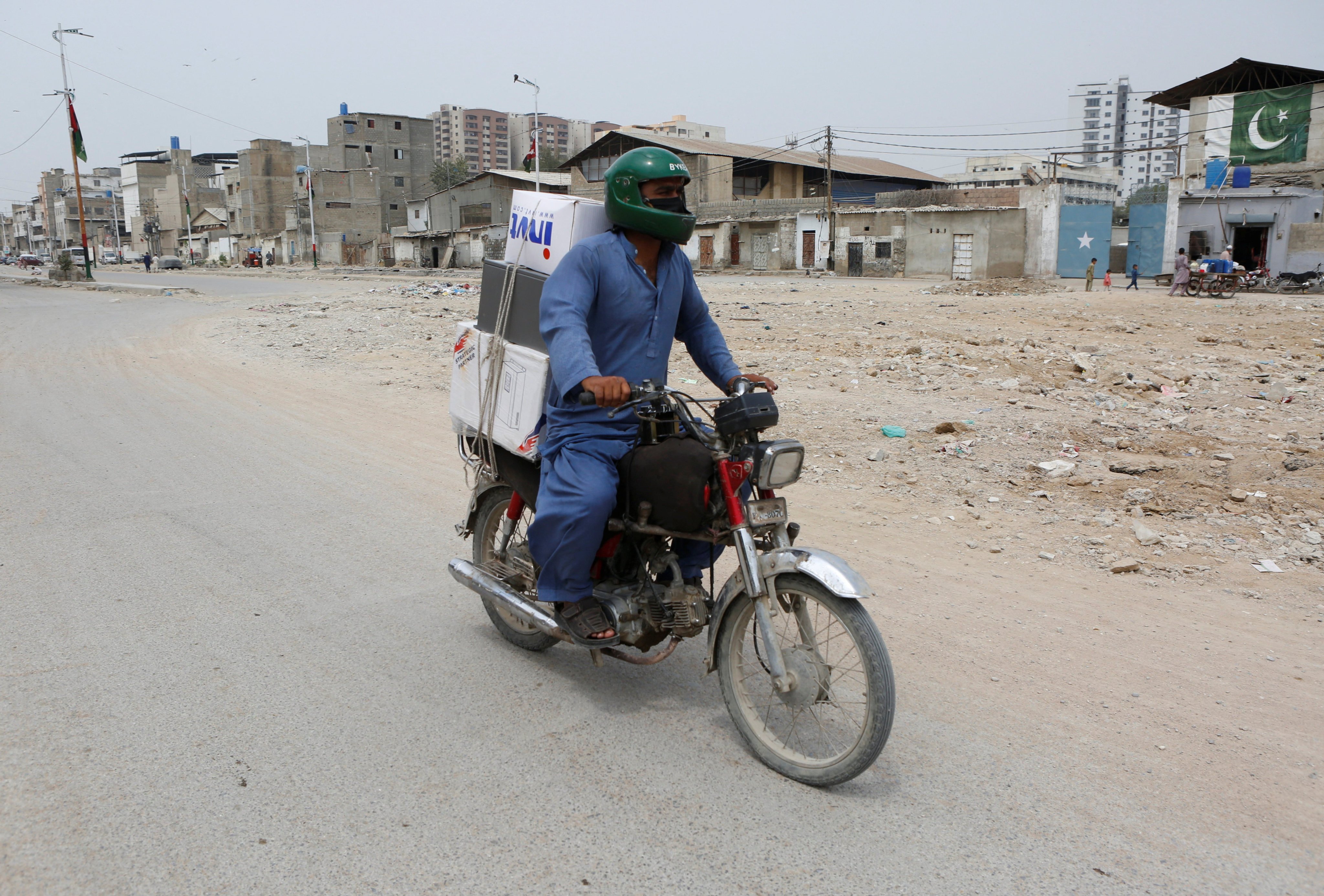 Malik Mohsin Ali, a rider for Bykea, ride-hailing and delivery platform, heads to deliver parcels in Karachi, Pakistan, March 18, 2026. REUTERS/Asim Hafeez
