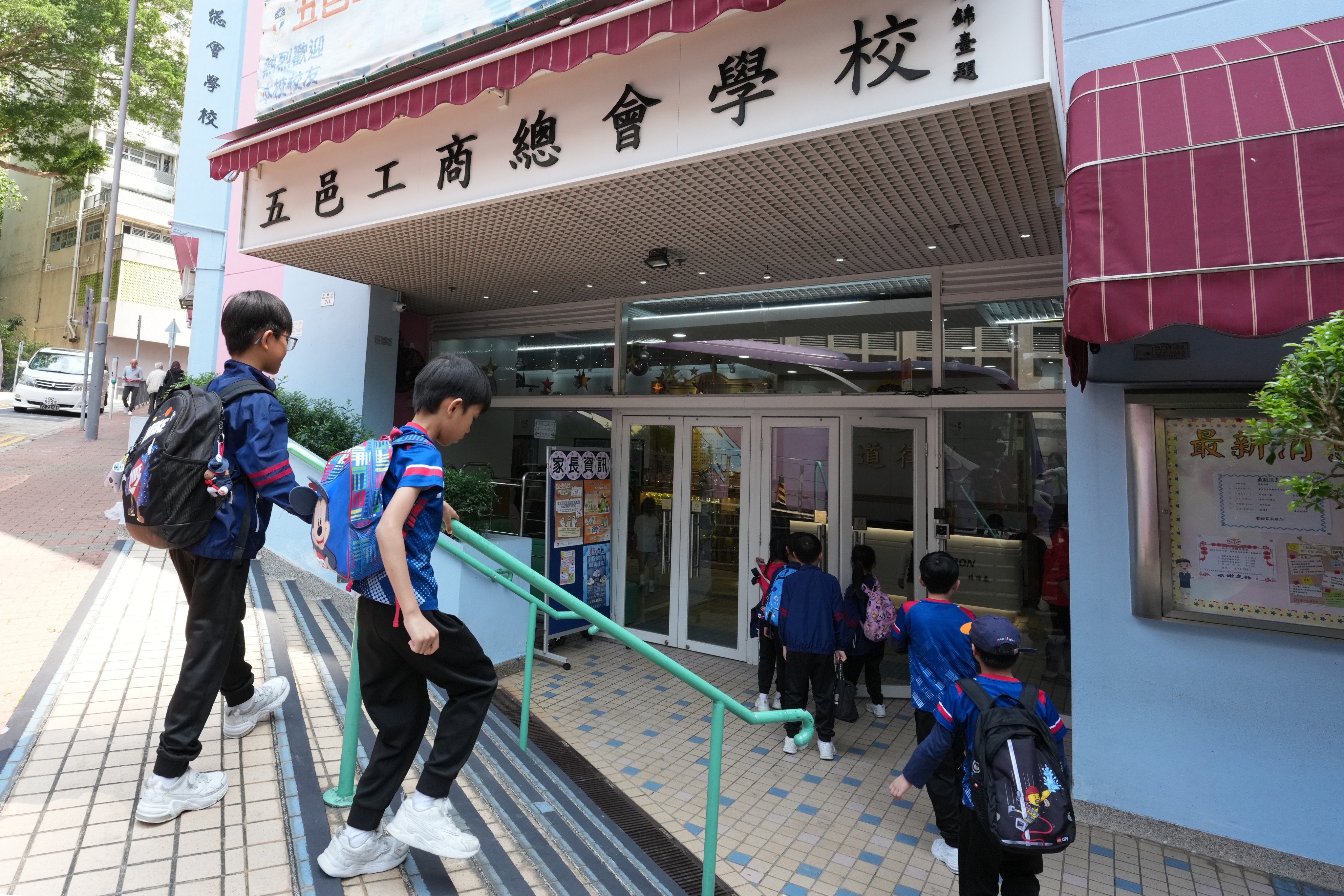 Students walk into the Five Districts Business Welfare Association School in Cheung Sha Wan on March 18. Photo: Jelly Tse