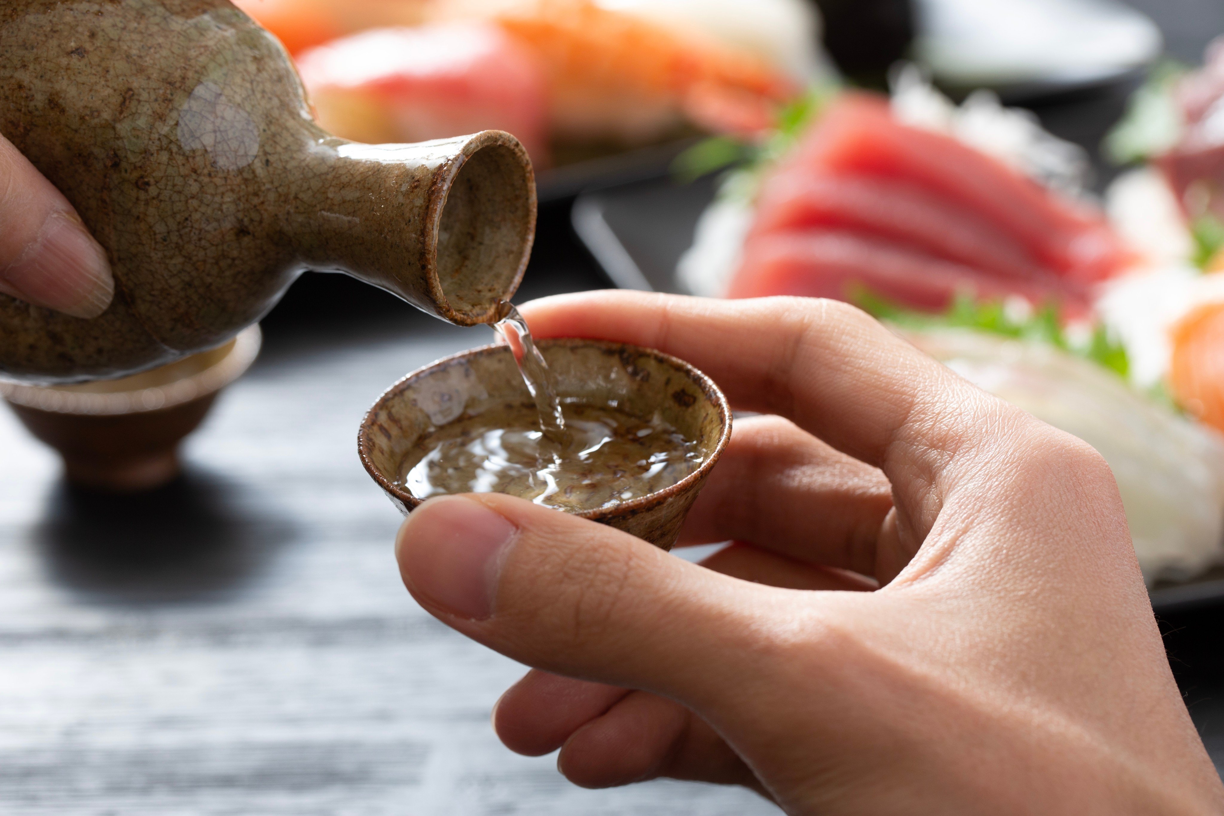 Pouring sake for others and refilling their glasses before they are empty is an act of hospitality and attentiveness in Japan. Photo: Shutterstock