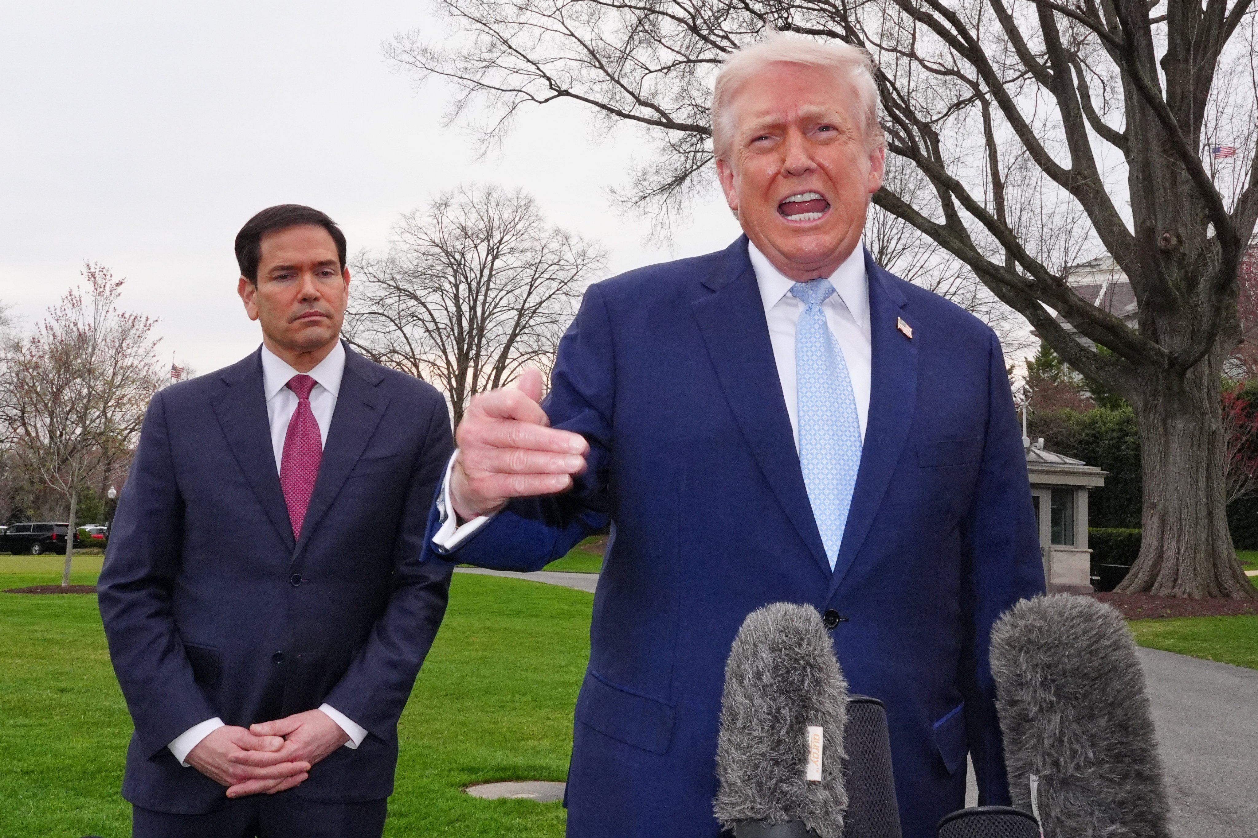 US President Donald Trump speaks with reporters at the White House on Friday, as Secretary of State Marco Rubio listens. Photo: AP