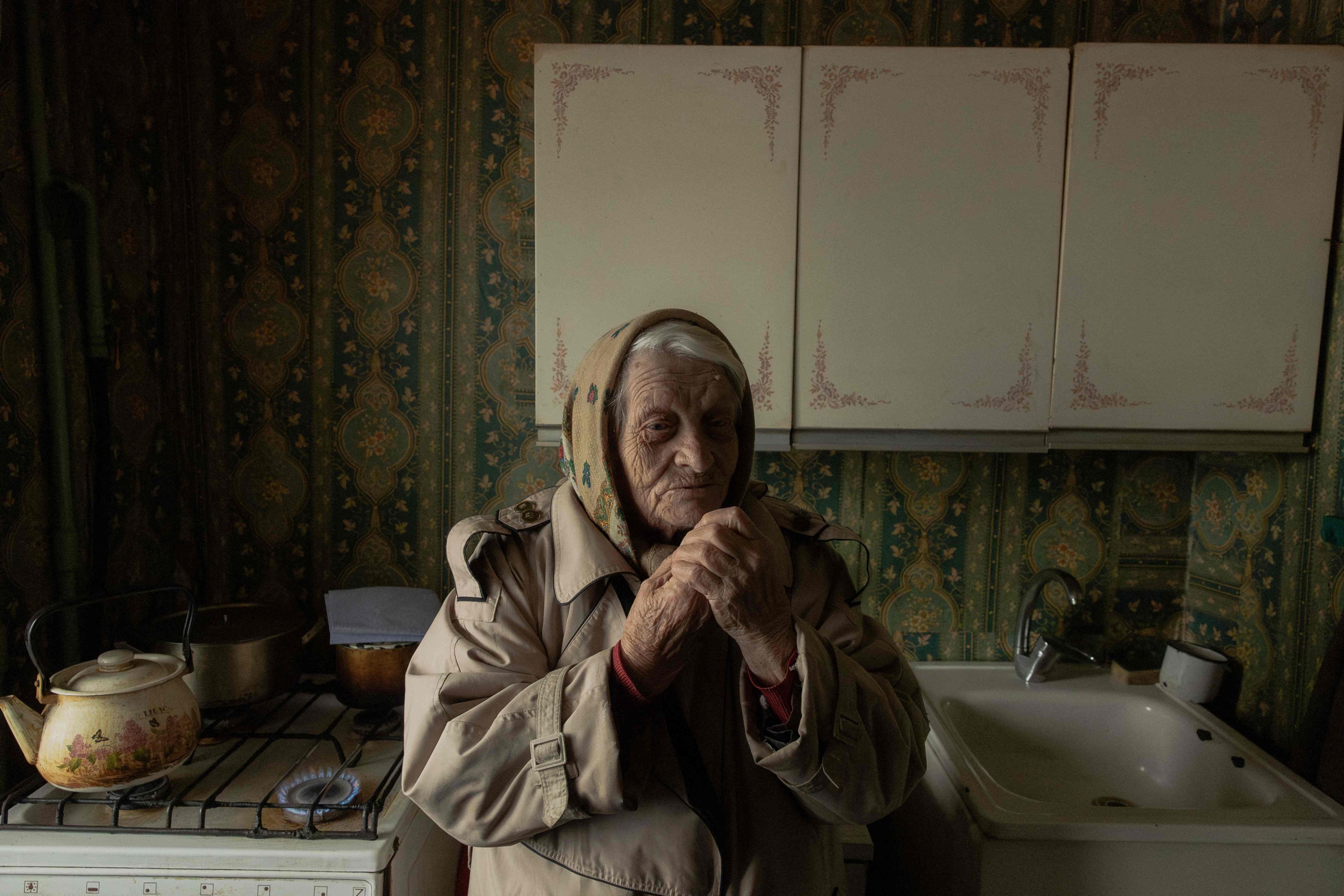 Yevheniia Yeremina, 89, stands in her kitchen using a gas stove to warm her apartment, which has no electricity and heating, in Kyiv on January 26. Russia has often attacked Ukrainian energy infrastructure amid its invasion. Photo: AFP