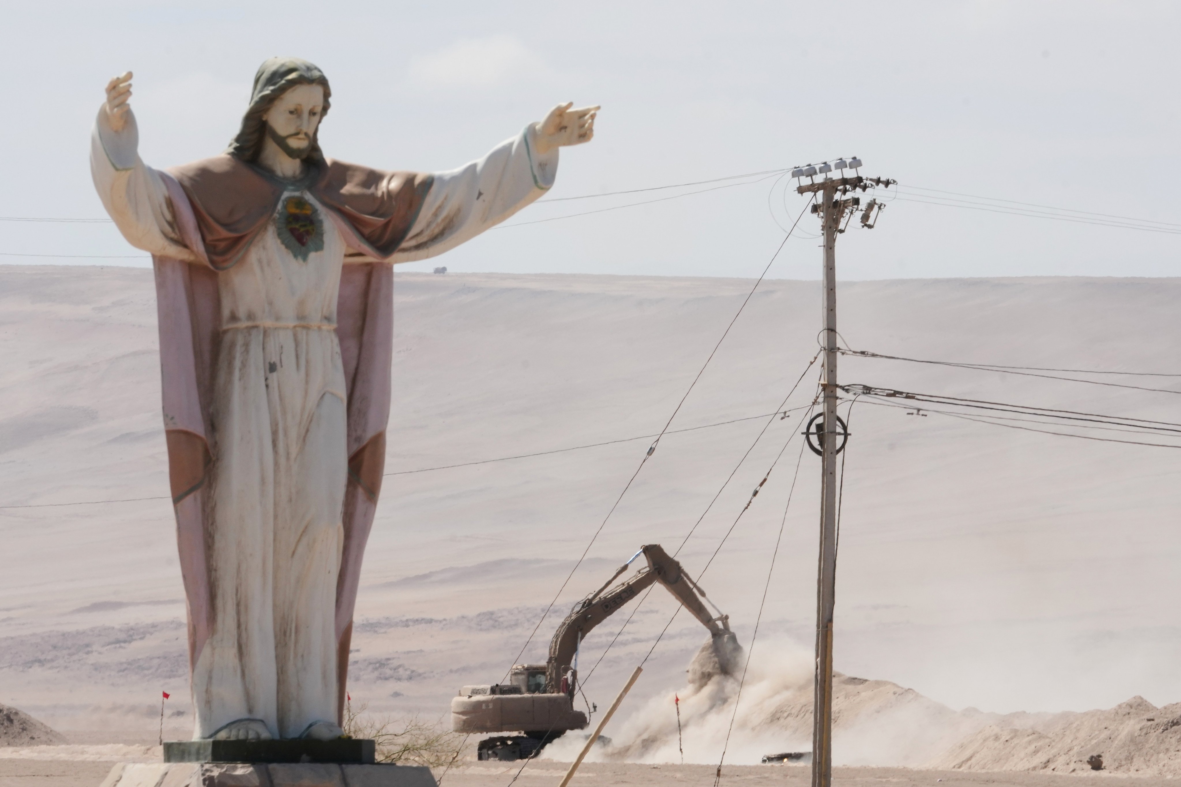 An excavator digs up soil to install barriers near “Cristo de la Paz” at the Chile–Peru border crossing in Chacalluta, Arica province. Photo: AP