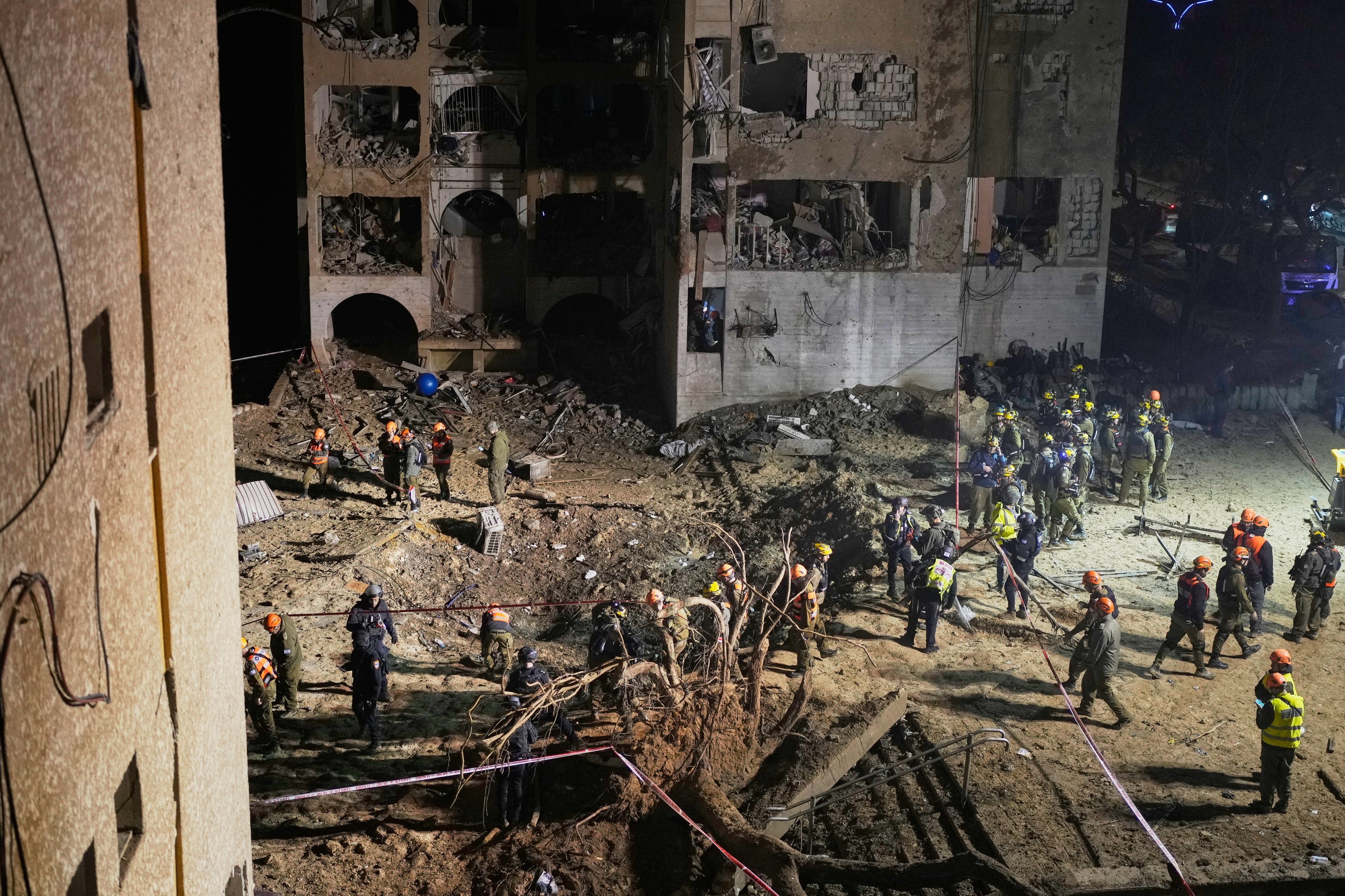 Israeli security forces and rescuers work at the site struck by an Iranian missile in Arad, southern Israel, on Sunday. Photo: AP