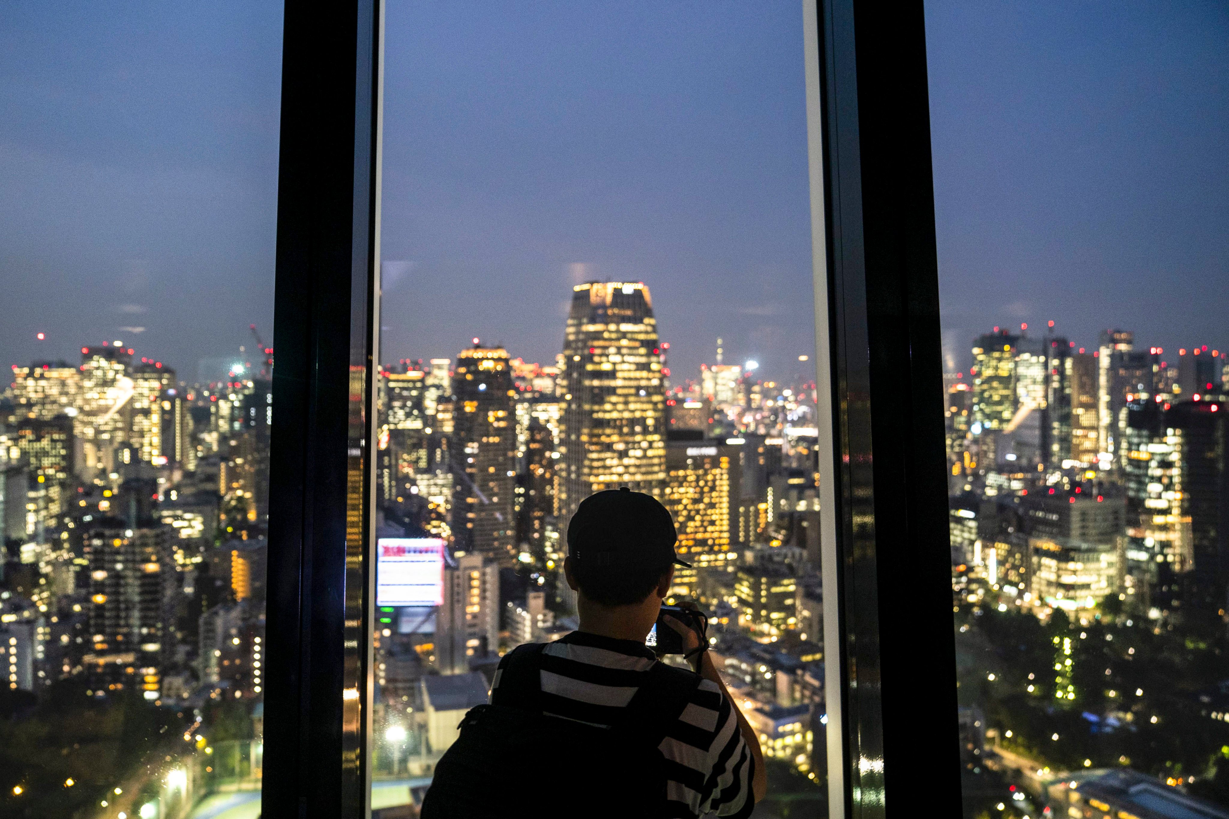 A visitor takes photos of Tokyo’s skyline. File photo: AP