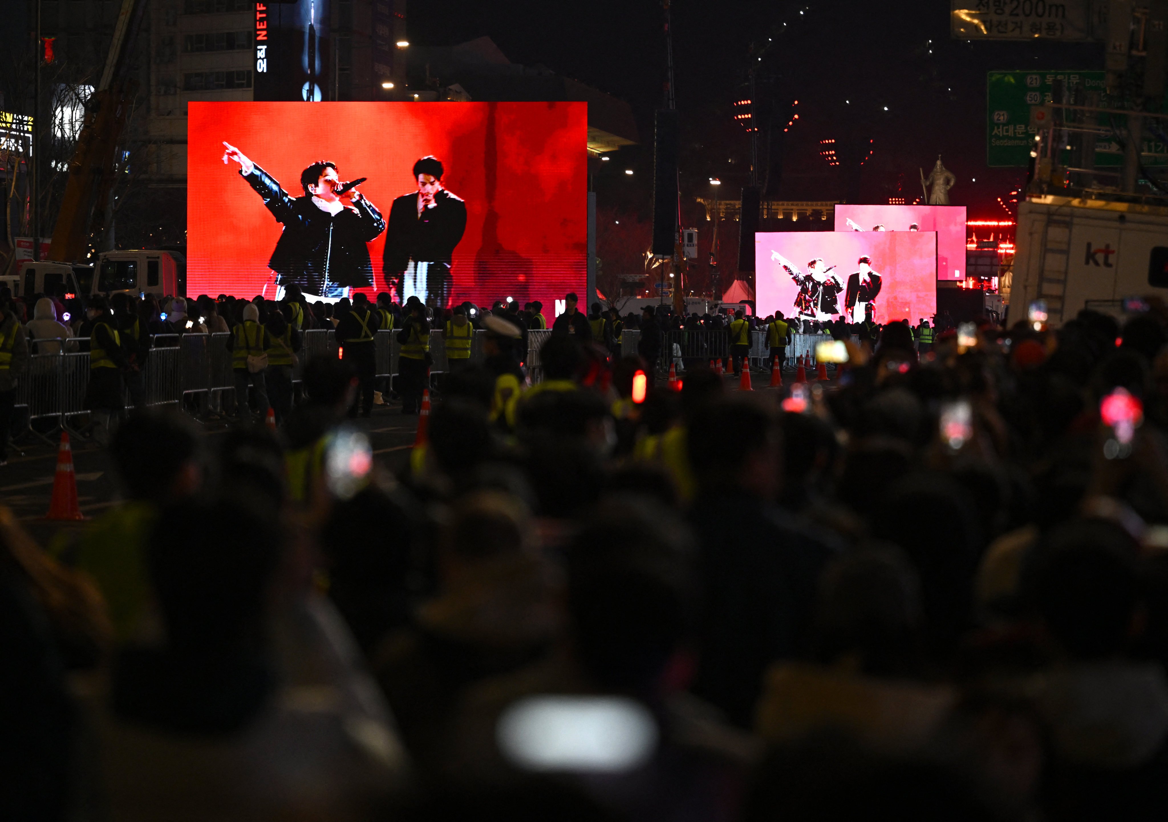 BTS fans watch the comeback concert of K-pop boy group BTS on screens at the venue in Seoul on March 21, 2026. South Korean megastars BTS reunited on March 21 for their first show in nearly four years, blowing away enormous crowds in Seoul for a K-pop extravaganza livestreamed to millions more worldwide. (Photo by Jung Yeon-je / AFP)