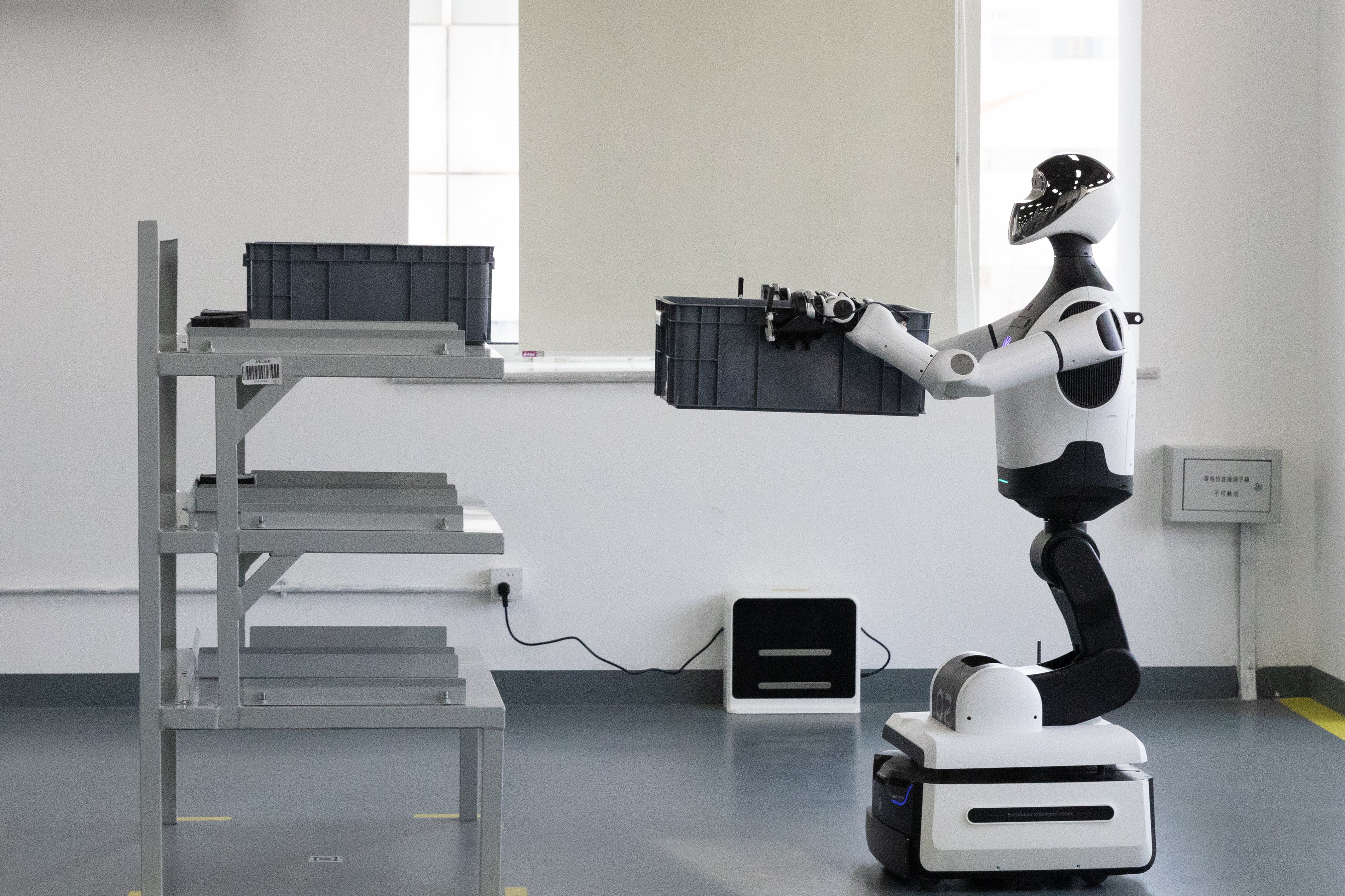 A robot helps with a task during a media tour to the Beijing Humanoid Robot Pilot Verification Platform, in Beijing on March 20. Photo: EPA