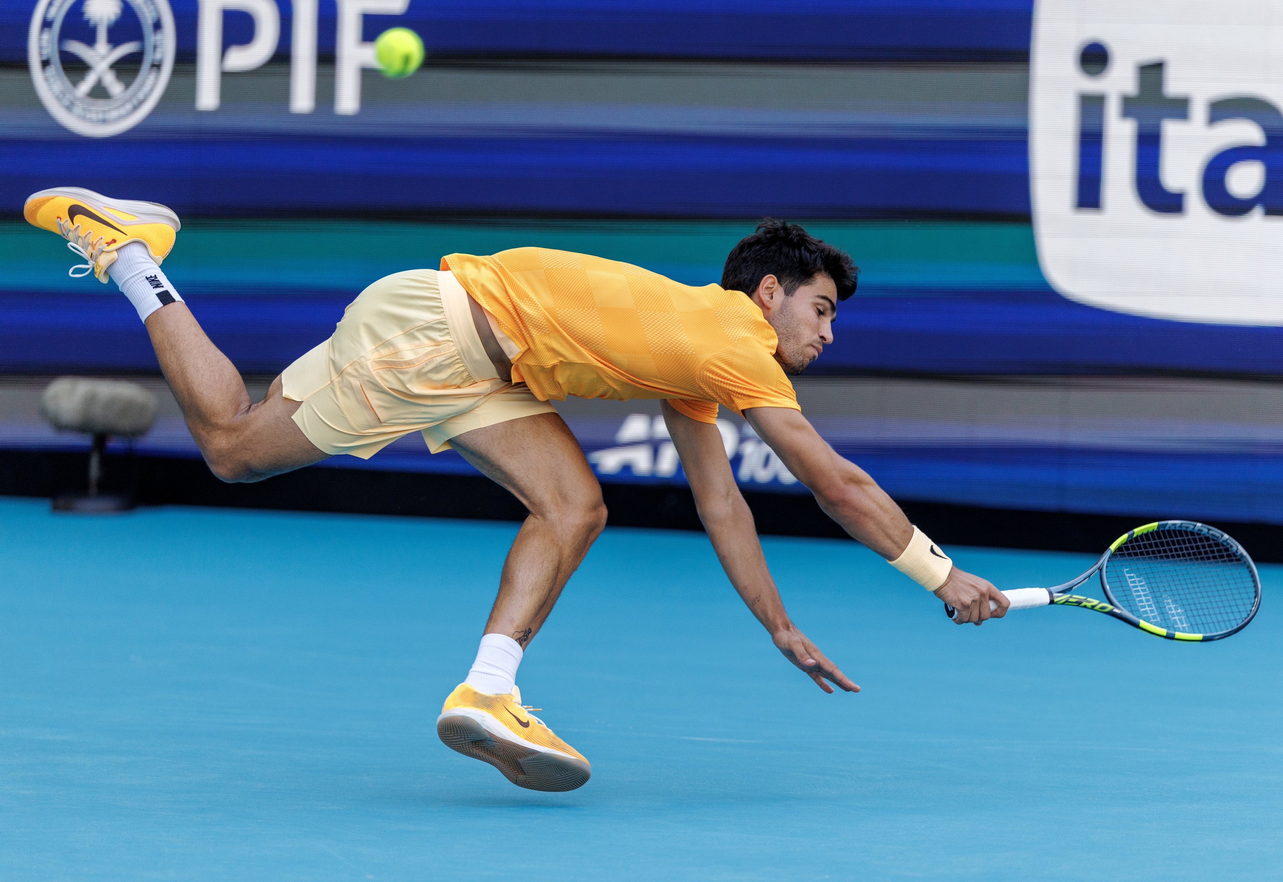 Carlos Alcaraz scrambles to get the ball back during his shock Miami Open defeat by Sebastian Korda. Photo:  EPA
