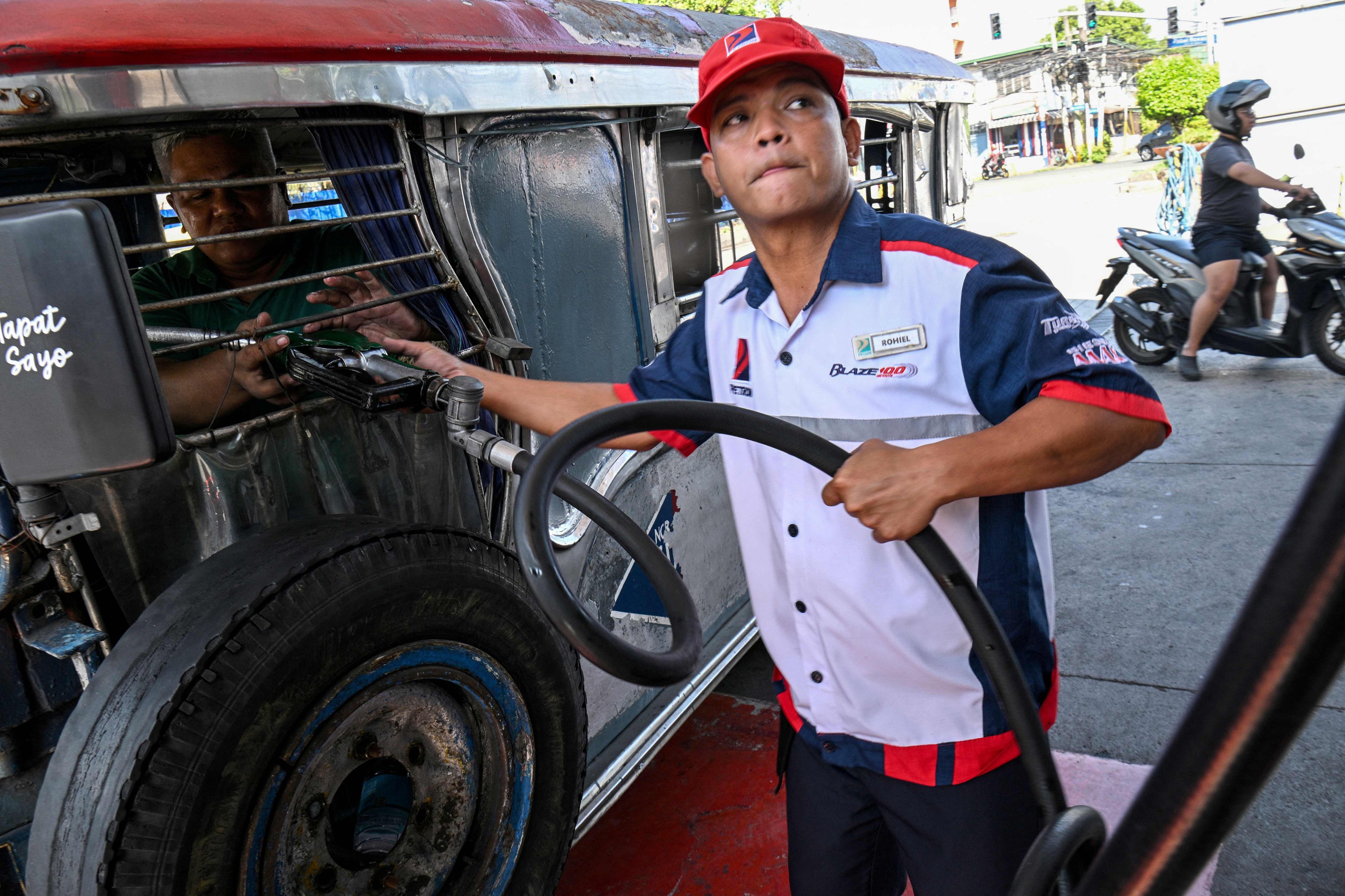 A Jeepney driver refuels his vehicle with diesel at a fuel station in Manila on Monday. Photo: AFP
