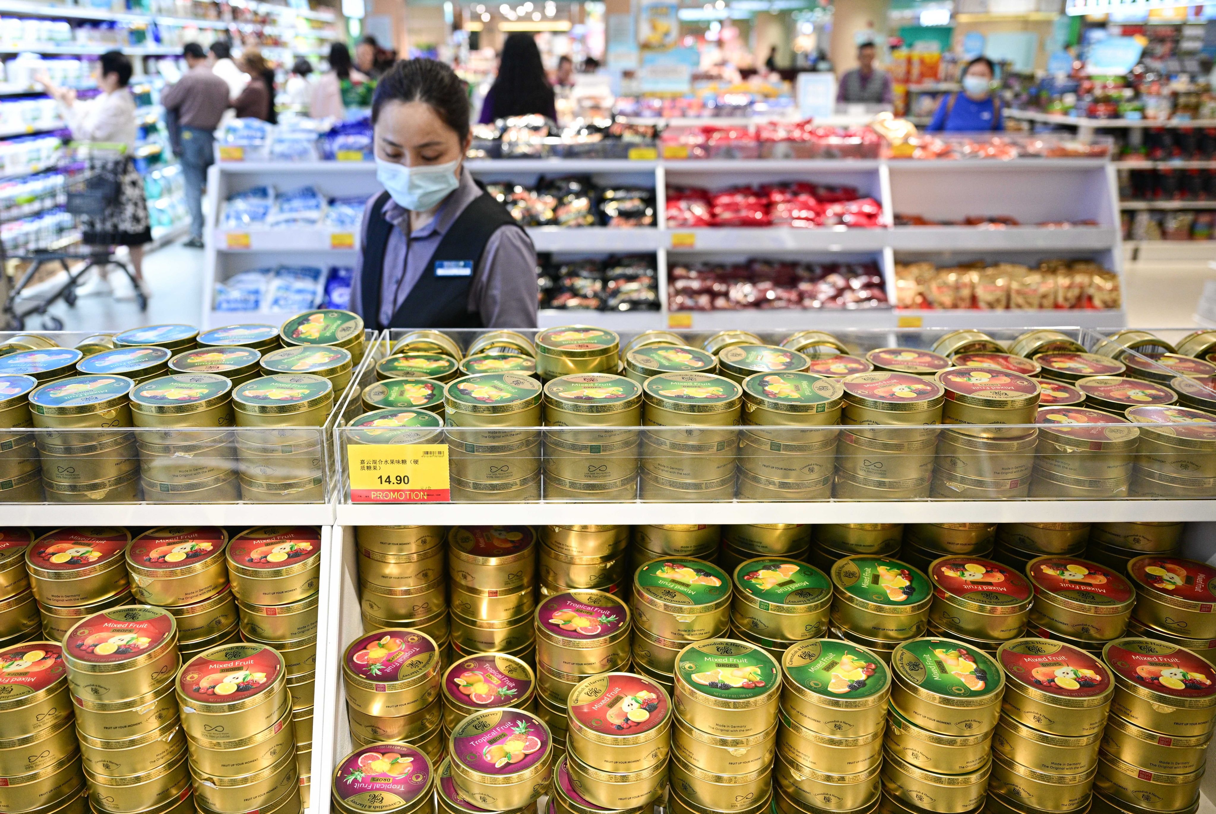 A worker keeps an eye on the shelves of a duty-free grocery shop in  Hainan province. Photo: Xinhua