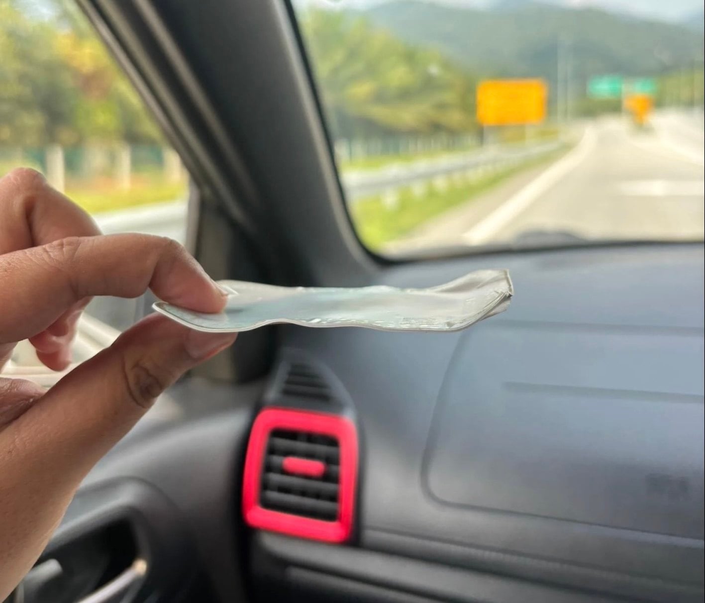 A Malaysian from Perak shows a toll payment card warped by the extreme heat affecting the country’s northern region. Photo: Threads/lltlps