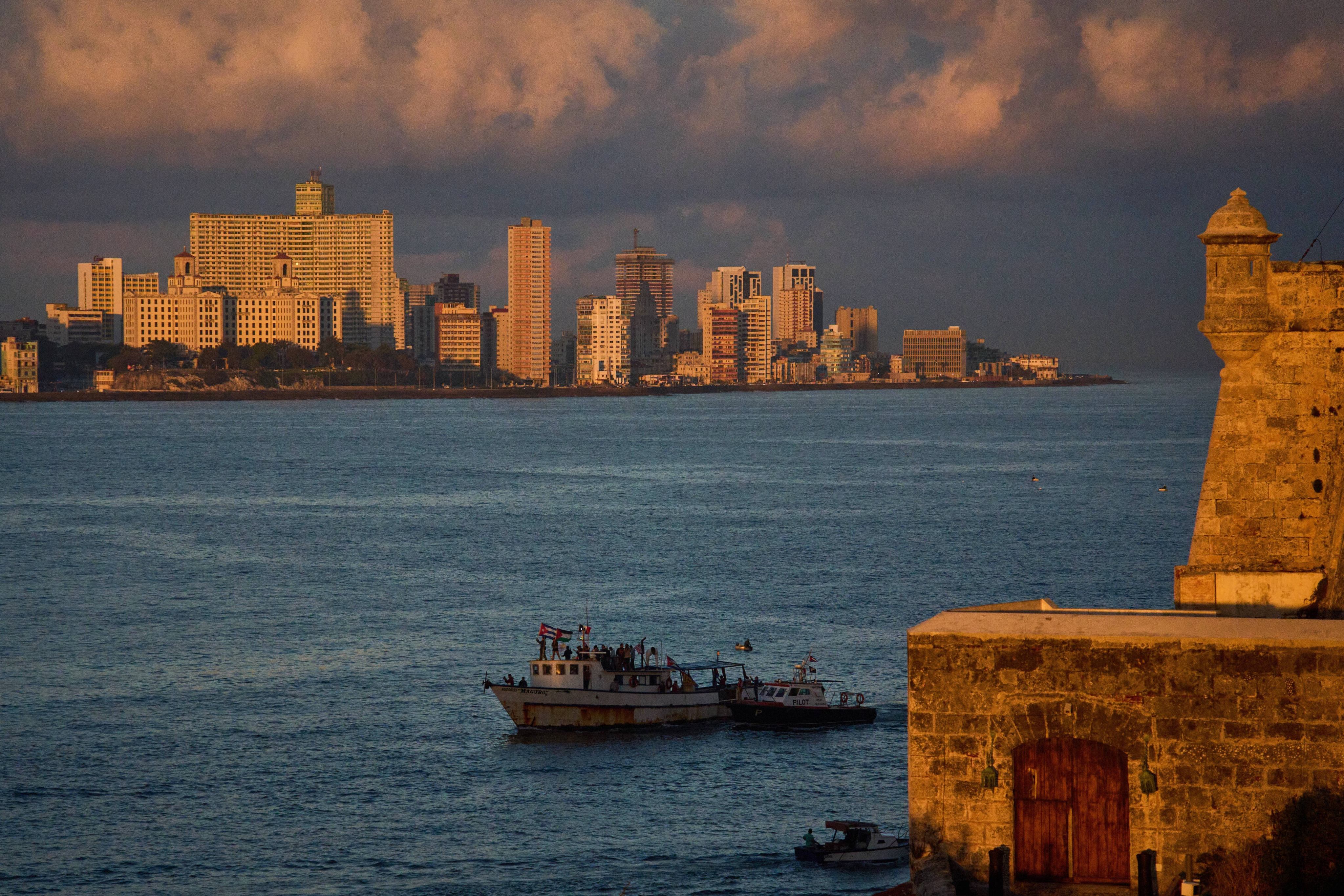 Activists wave Cuban and Palestinian flags from the vessel Maguro in Havana Bay, Cuba. Photo: AP