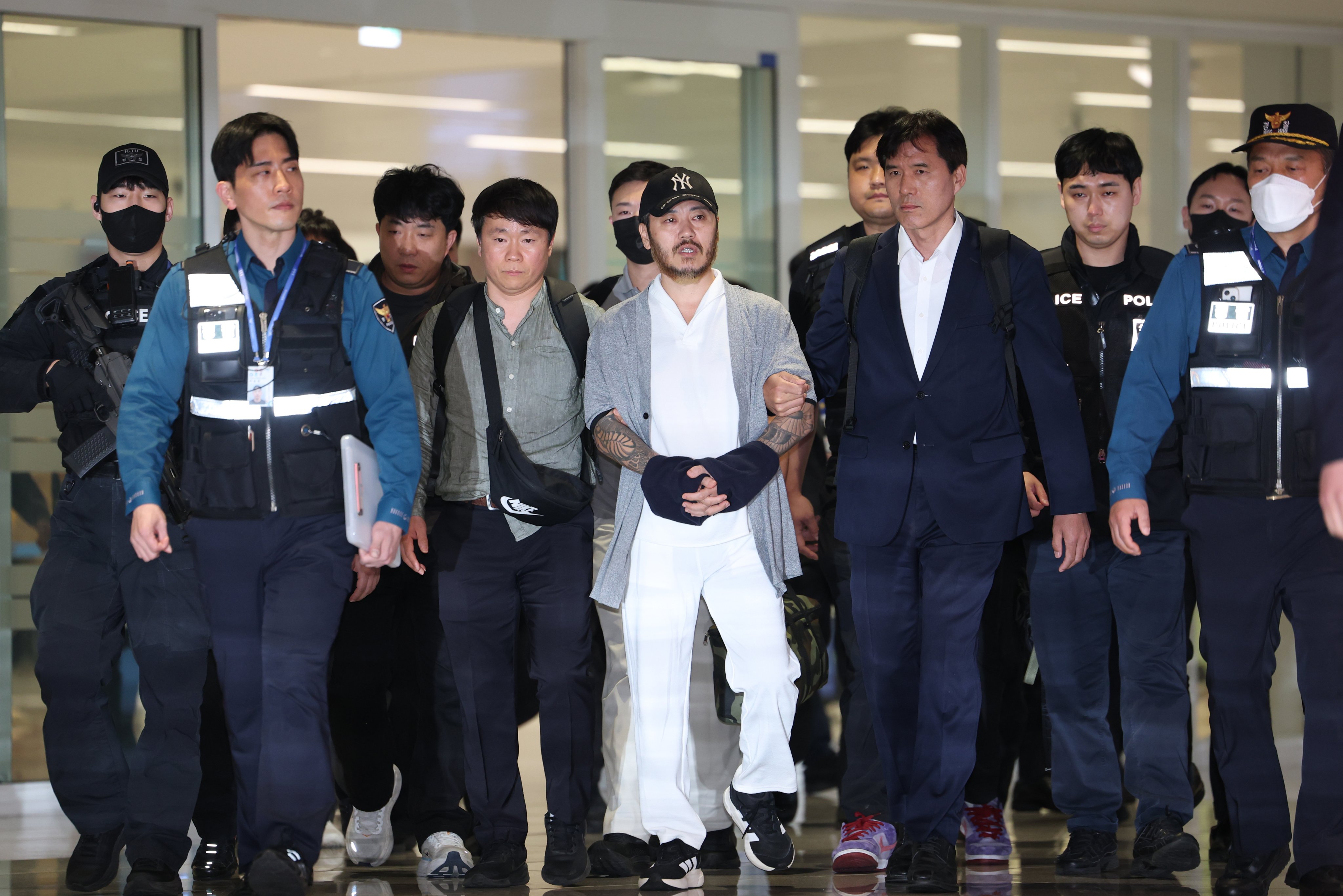 Park Wang-yeol (centre), a South Korean national detained in the Philippines, arrives at Incheon International Airport in South Korea on Wednesday. Photo: Yonhap/EPA