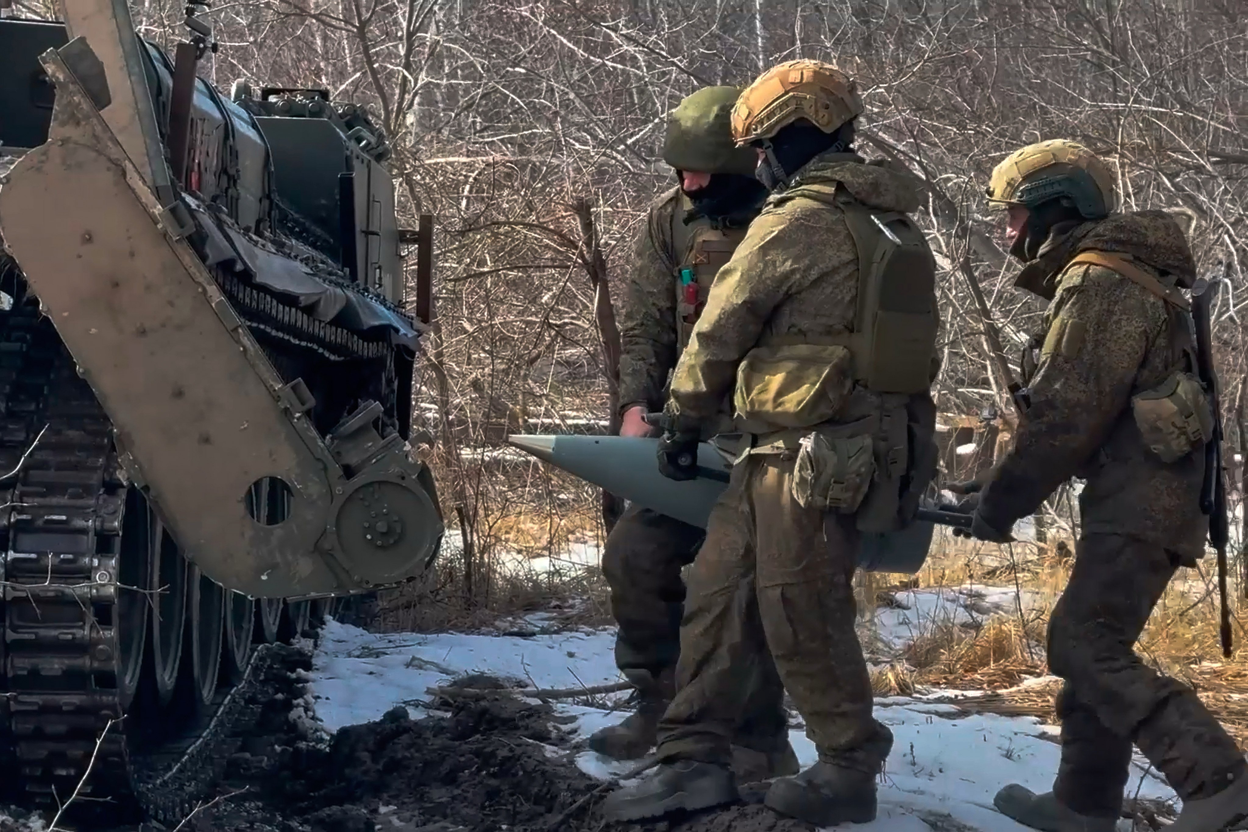 Russian soldiers carry ammunition for a self-propelled cannon to fire towards a Ukrainian position. Photo: Russian Defence Ministry via AP