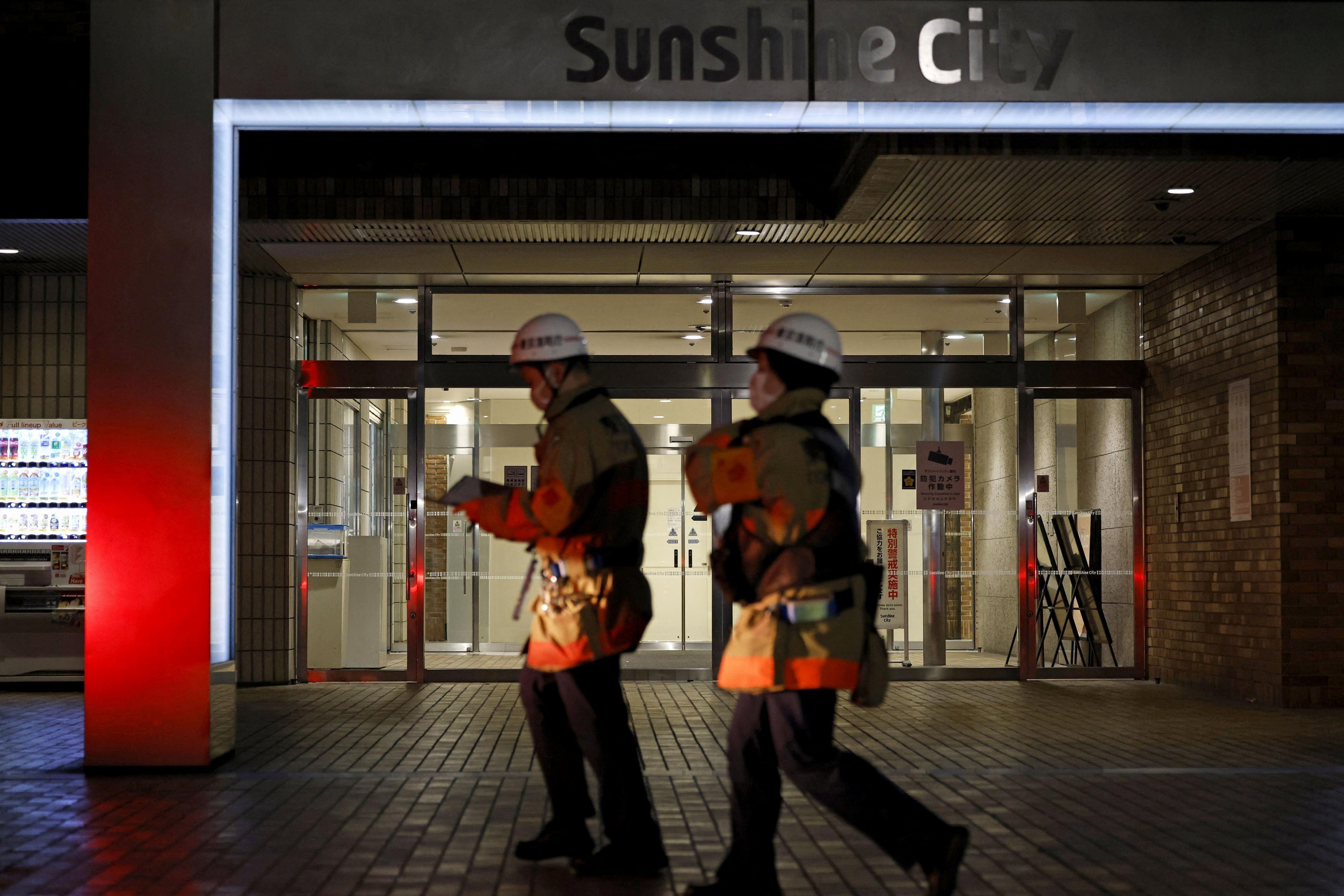Rescue workers walk in front of a commercial complex where a female employee at a Pokemon merchandise shop was stabbed to death at Ikebukuro district in Tokyo on Thursday. Photo: via Reuters