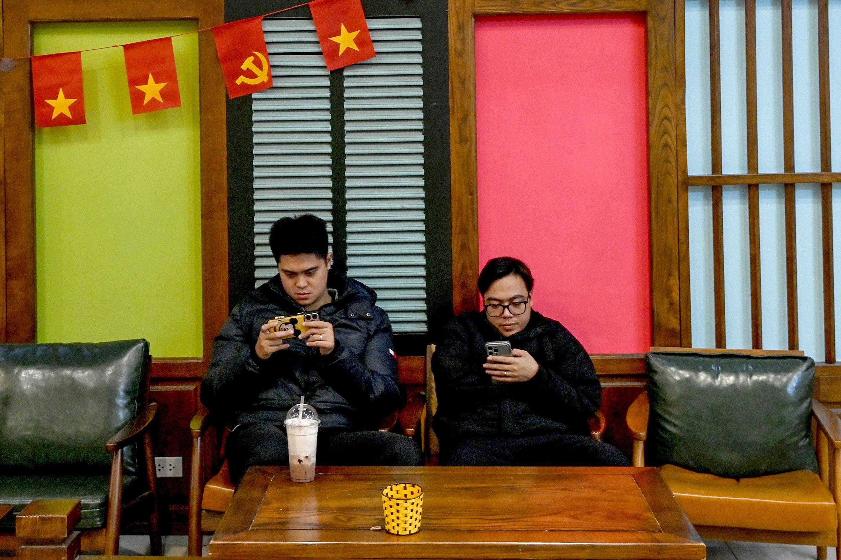 Men use their phones at a cafe in Hanoi, Vietnam, in January. Photo: AFP