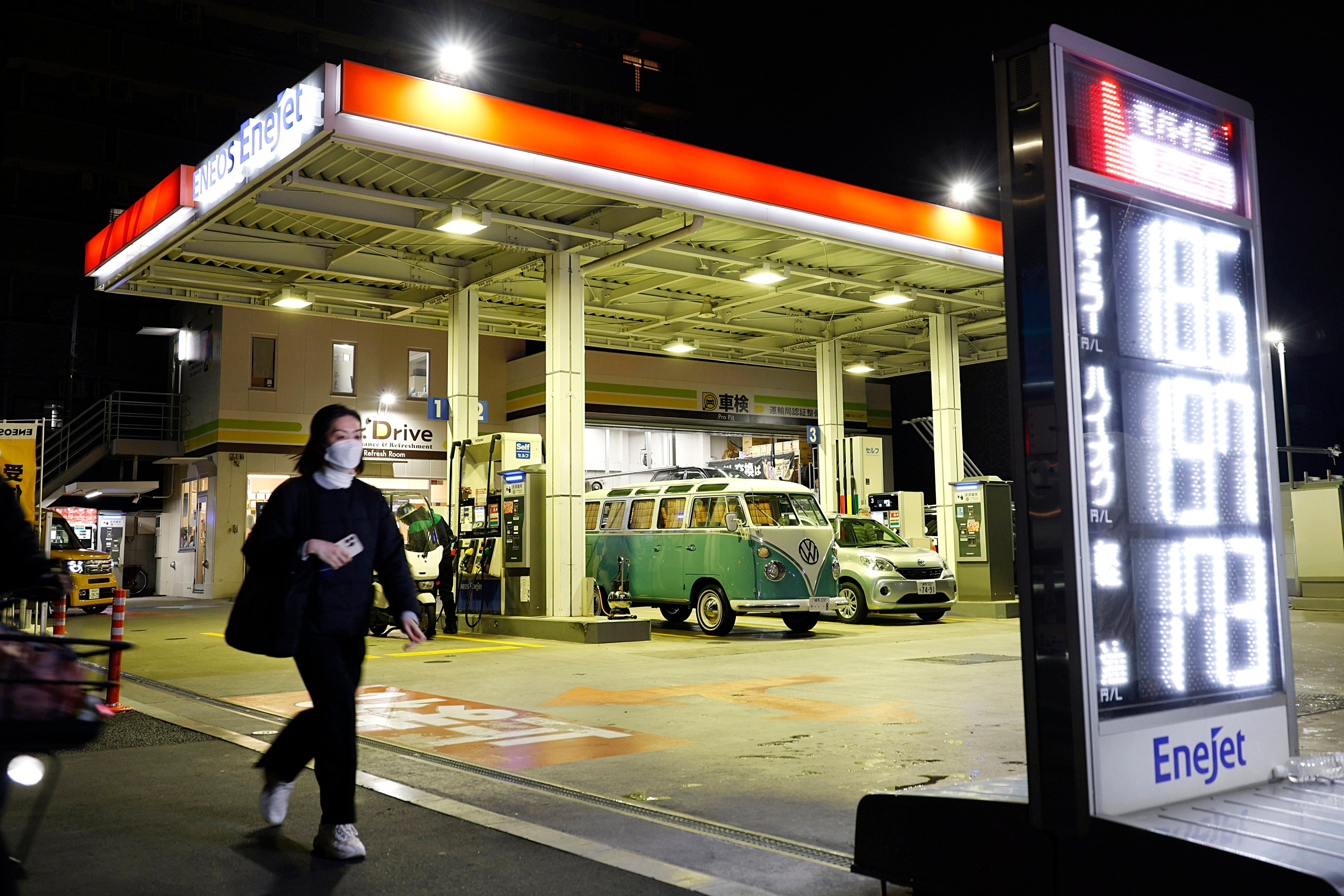 A pedestrian walks past a petrol station in Tokyo, Japan, on March 18. Photo: EPA