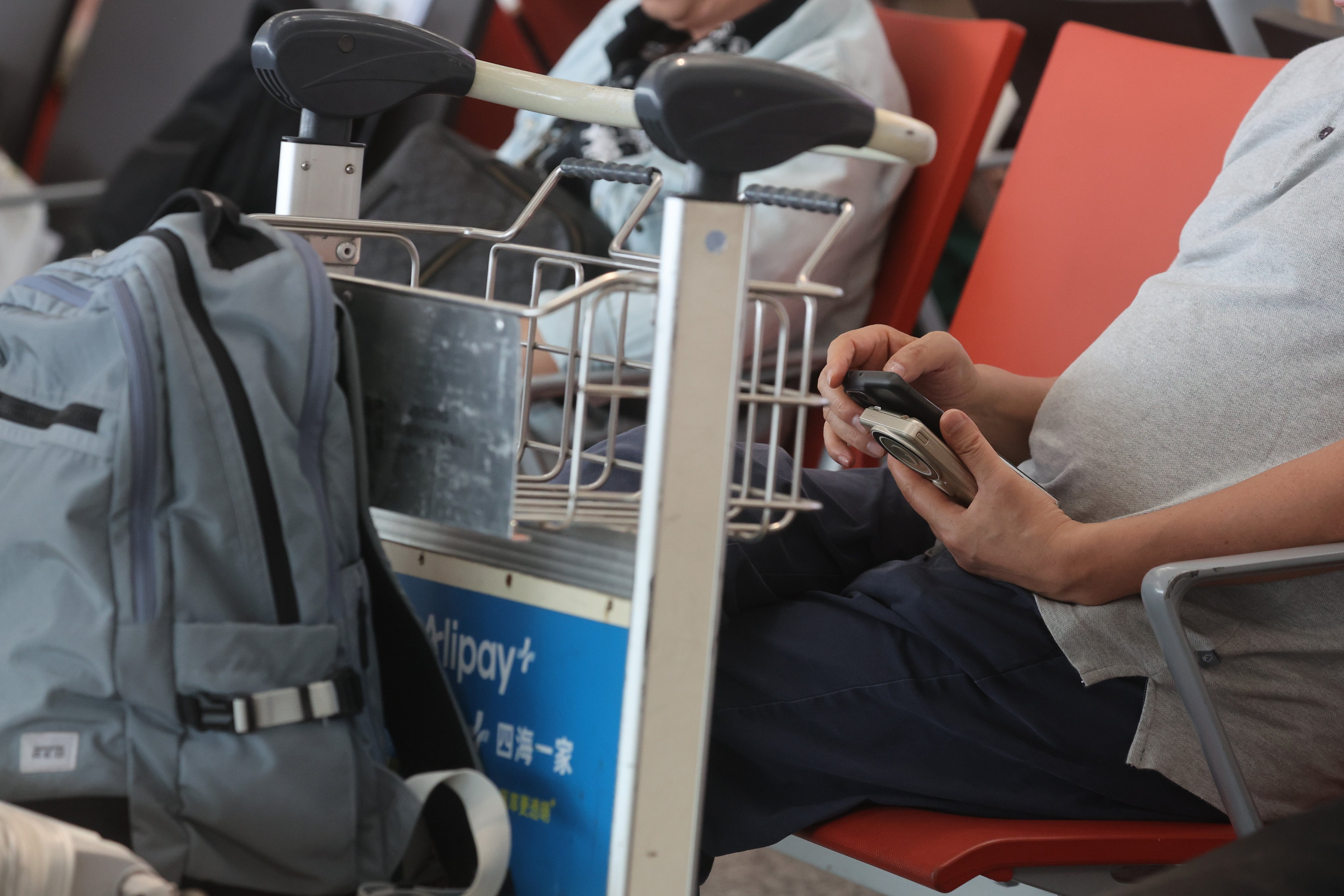 A passenger uses a power bank at Hong Kong International Airport in Chek Lap Kok. The Civil Aviation Department issued notice for all flights departing from the Hong Kong International Airport, each passenger is allowed to carry no more than two power banks, which must be carried in carry-on baggage only. Recharging power banks is also prohibited during flights requirements.  29MAR26 SCMP / Edmond So