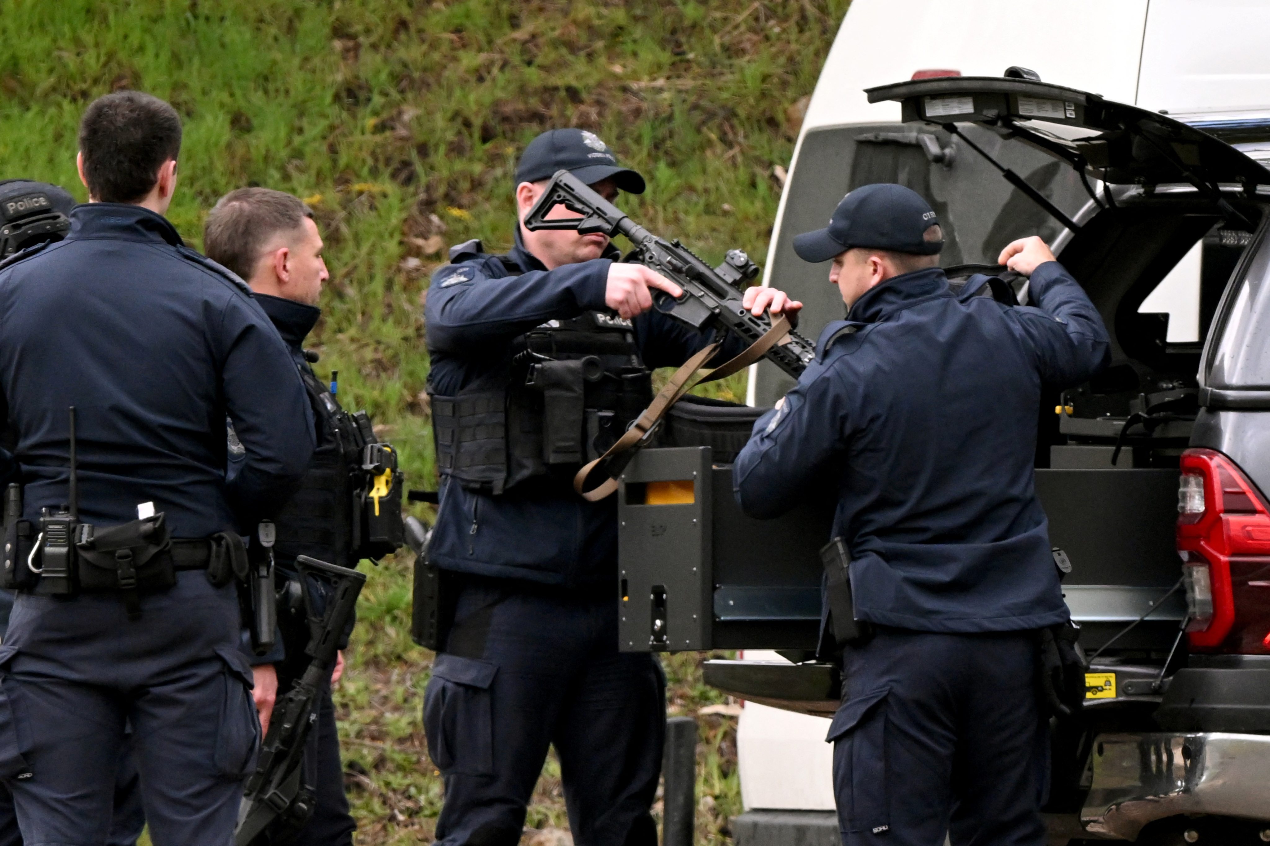 Armed police gather at a staging point near Porepunkah, Australia during a search for the fugitive linked to the murder of two police officers in August last year. Photo: AFP
