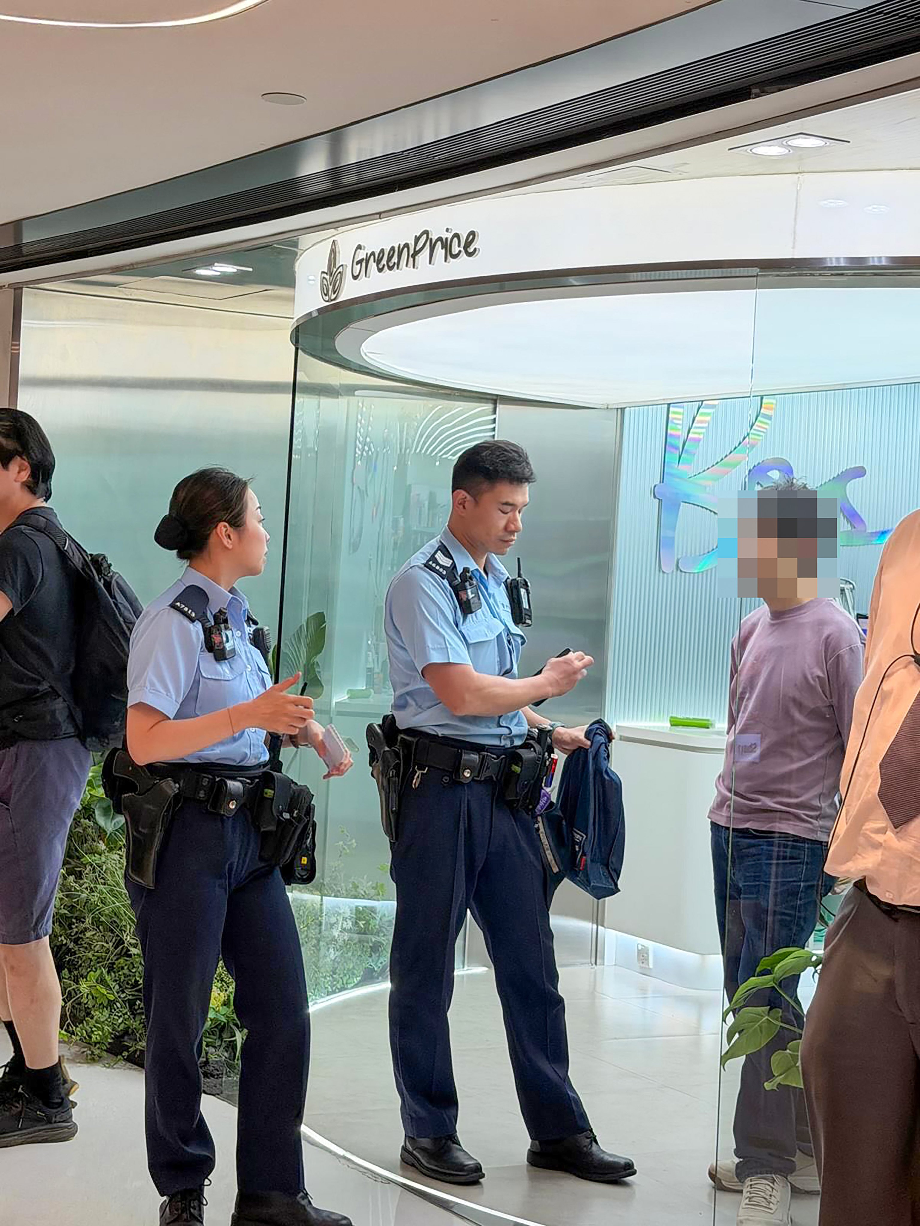 Hong Kong police question the man at New Town Plaza in Sha Tin. Photo: Threads / hazelwong