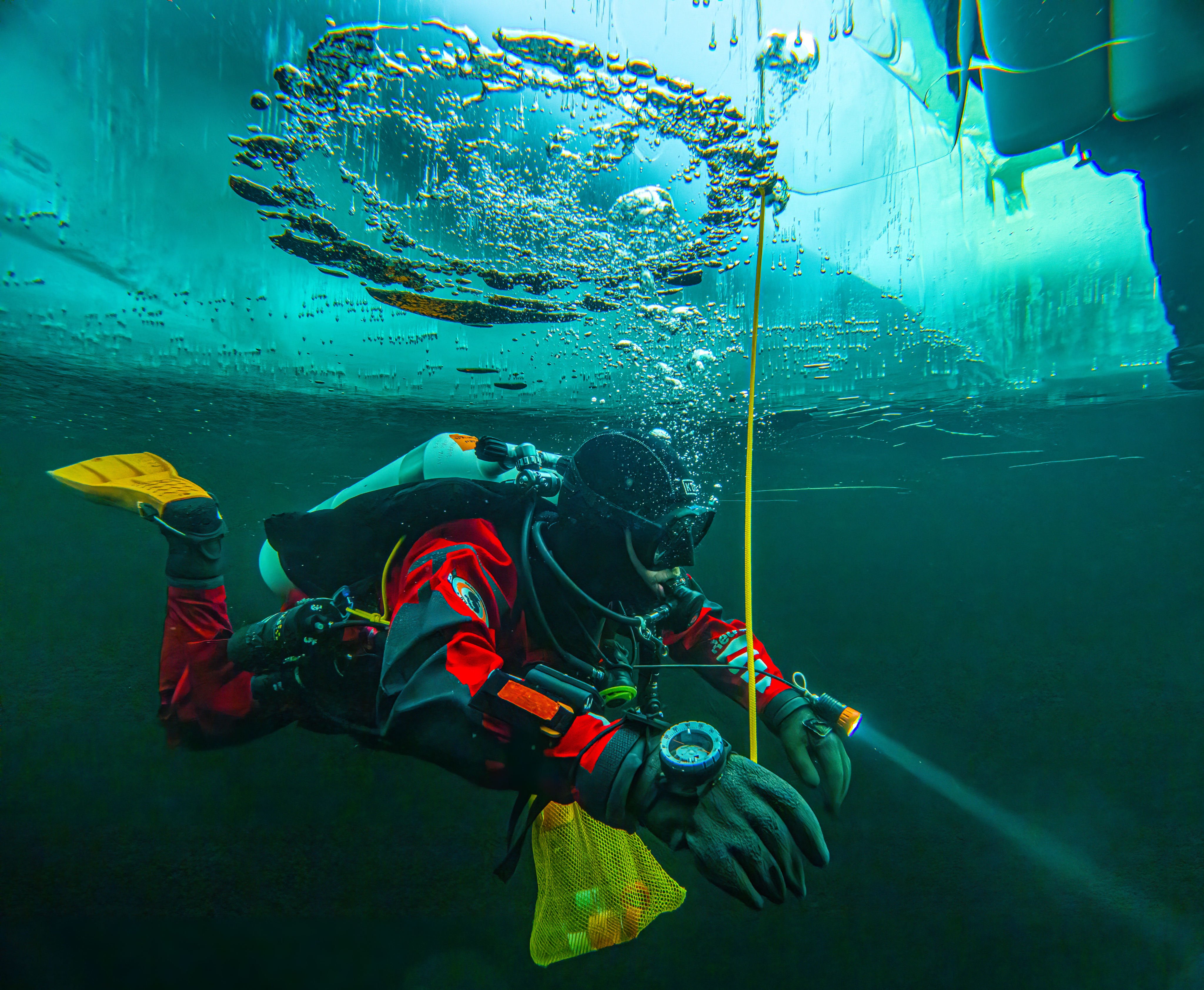 A diver swims under the ice during a Polar Scientific Diving class in Kilpisjarvi in Finland. Photo: AP