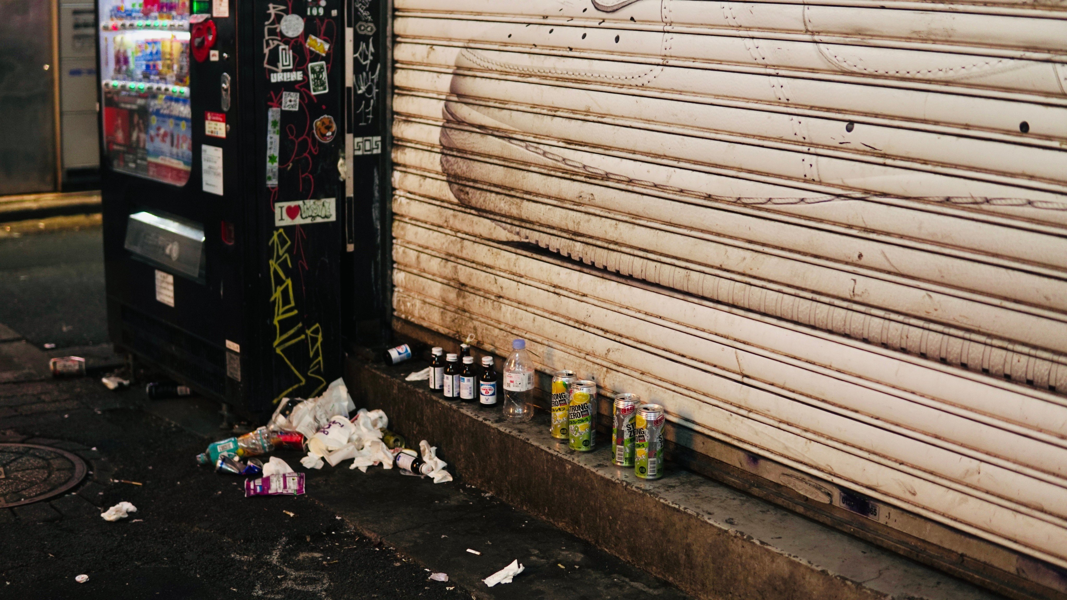 Aluminium cans, bottles, and other trash stashed next to a vending machine in Shibuya. Photo: Shutterstock