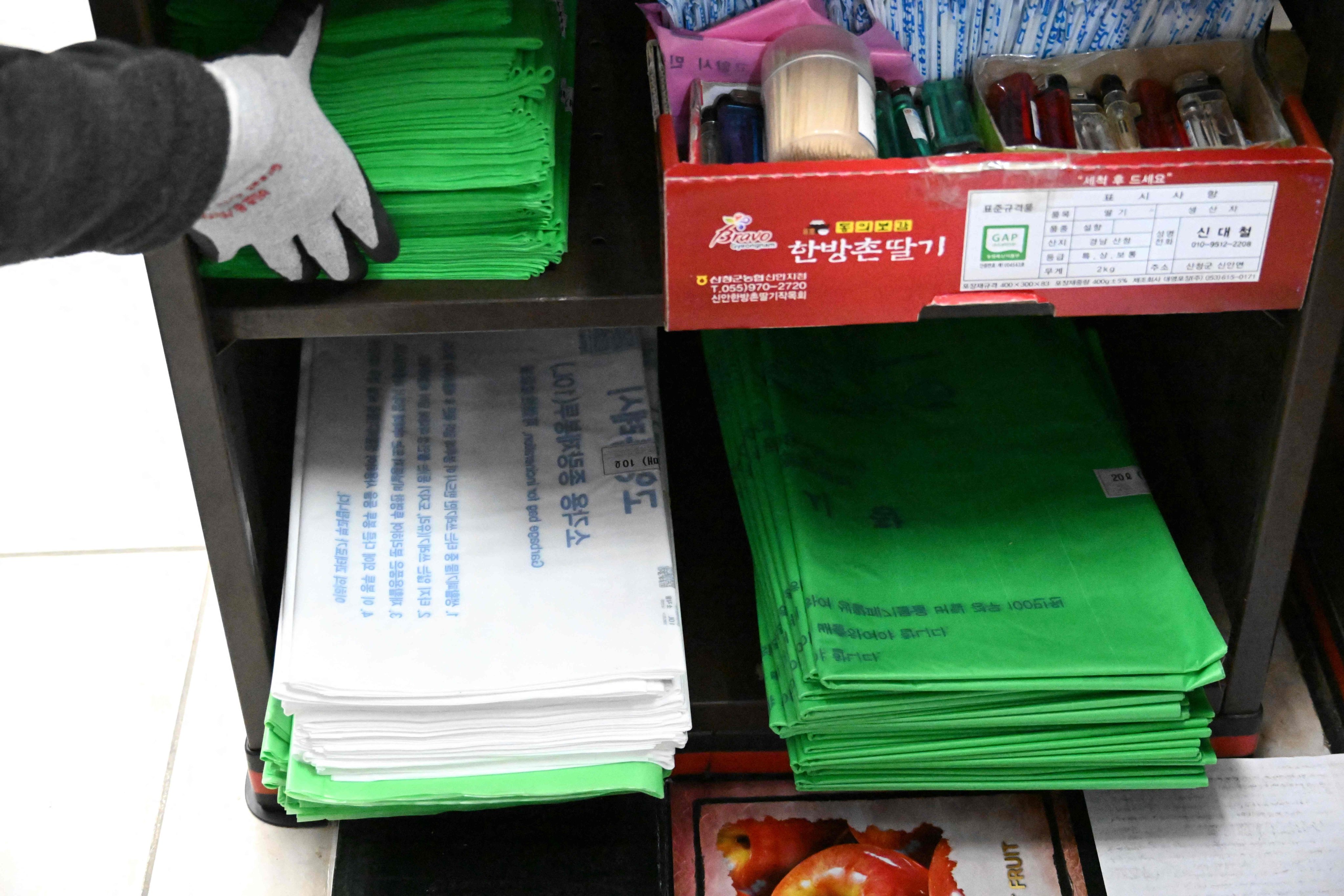 A cashier checks government-regulated bin bags at a checkout in Goyang, South Korea, on Monday. South Korea’s energy minister has sought to ease fears over shortages of plastic rubbish bags. Photo: AFP