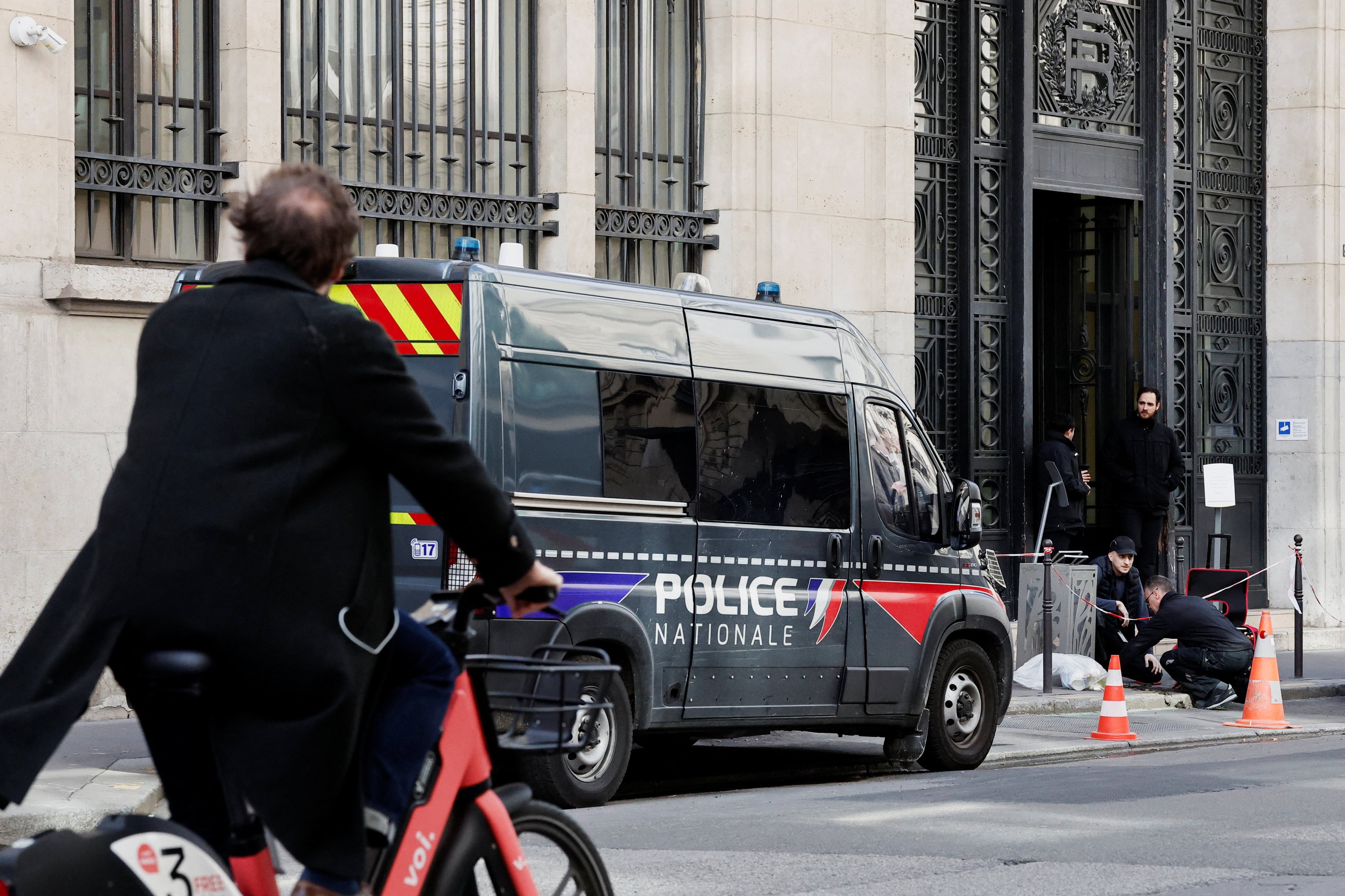 Private security members work next to a police van outside Bank of America’s Paris offices on Monday. Photo: Reuters