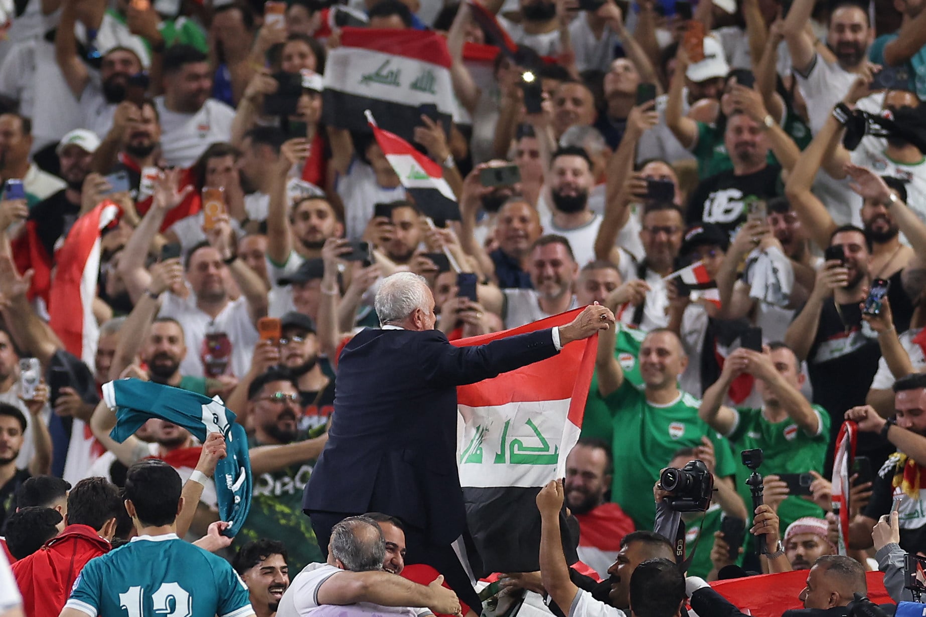 Iraq’s Australian coach Graham Arnold displays the national flag to the fans after winning the World Cup play-off against Bolivia in Mexico on Tuesday. Photo: AFP
