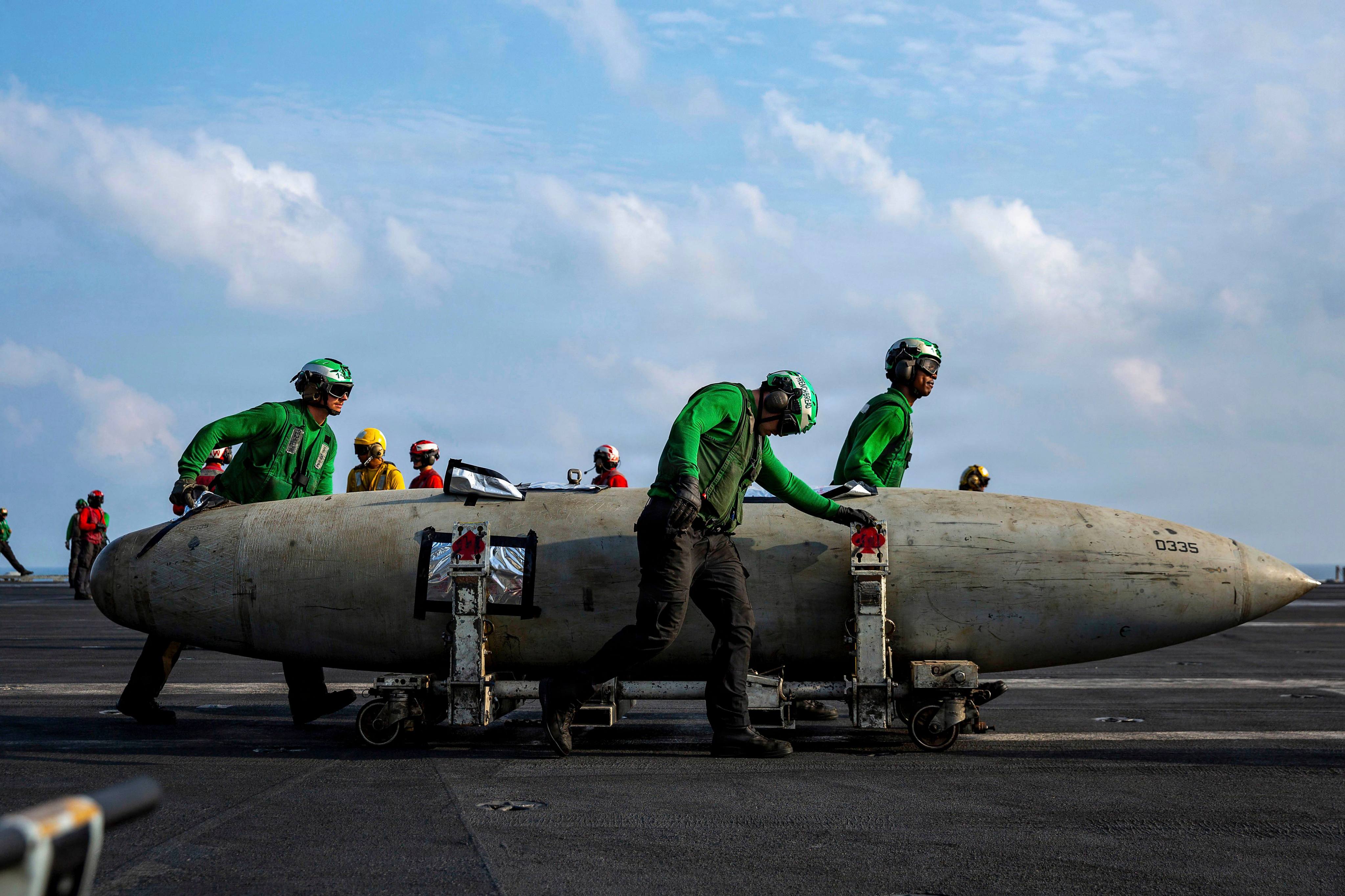 US Navy sailors move a F/A-18 fighter aircraft fuel tank on the flight deck of the Nimitz-class aircraft carrier USS Abraham Lincoln during Operation Epic Fury late last month. Photo: US Navy/dpa