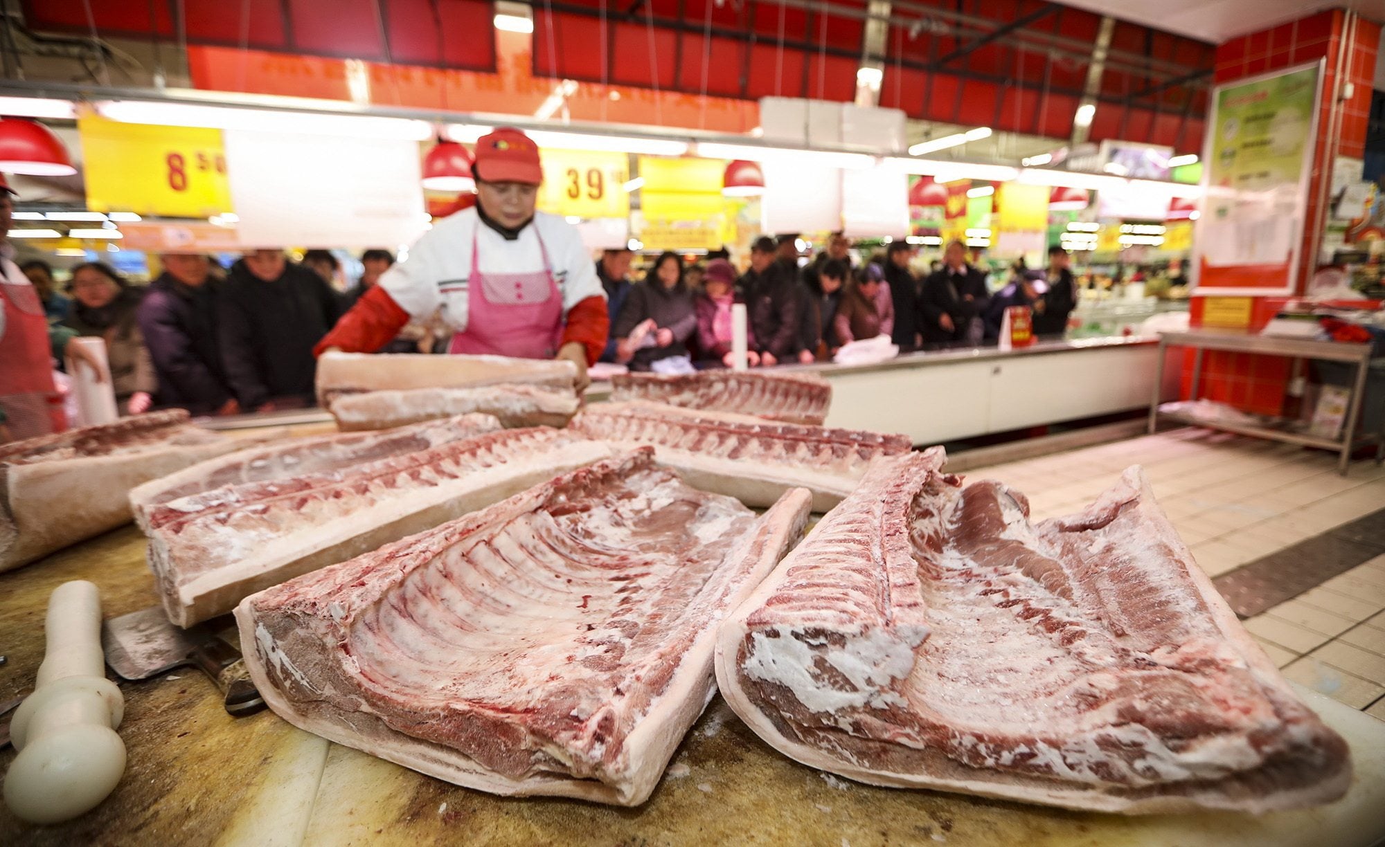 A supermarket employee cuts pork in Huaian city, Jiangsu province. Photo: Costfoto/Future Publishing via Getty Images