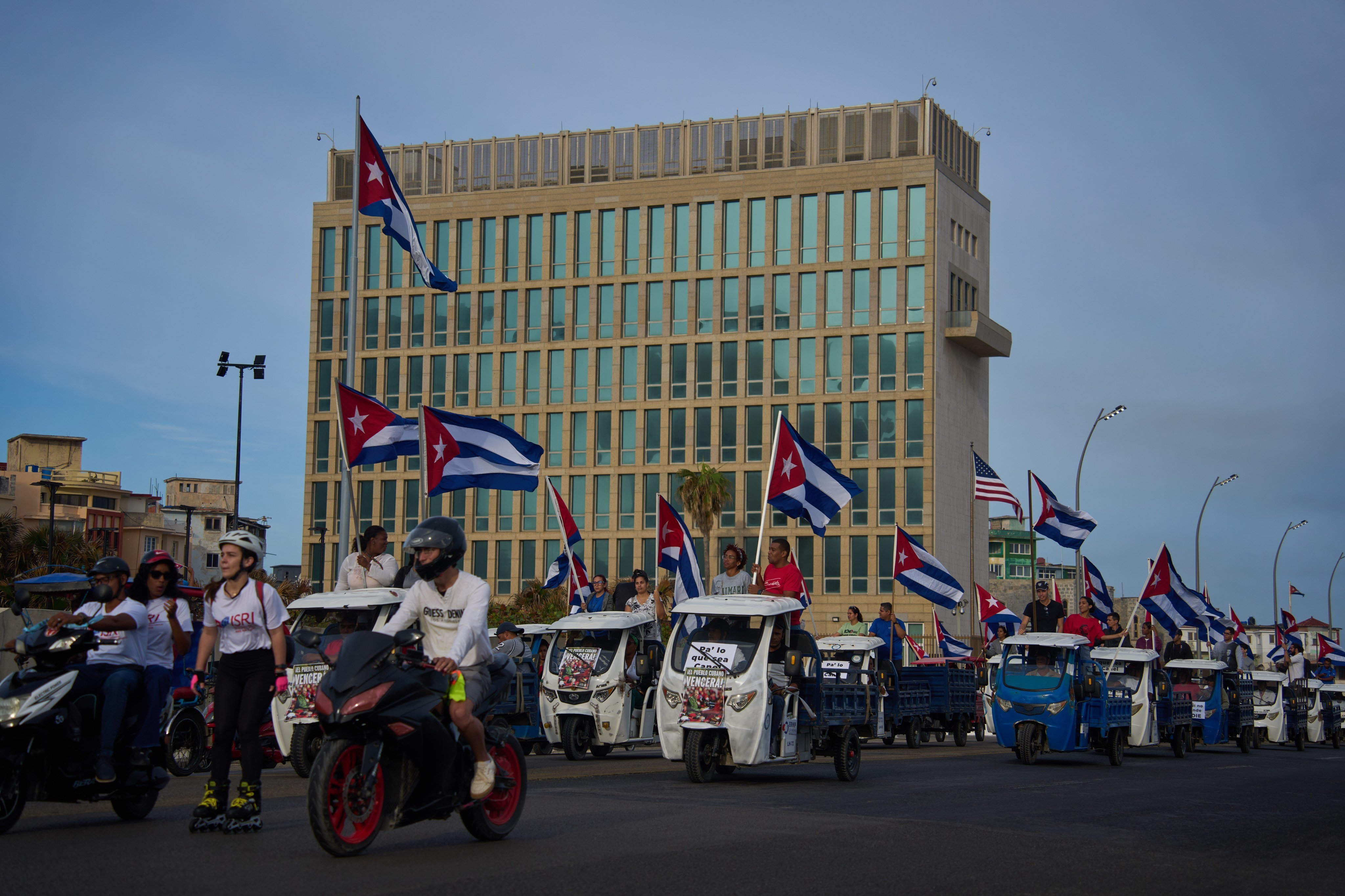 People ride past the US embassy in Havana during an anti-imperialist youth march on Thursday. Photo: AP