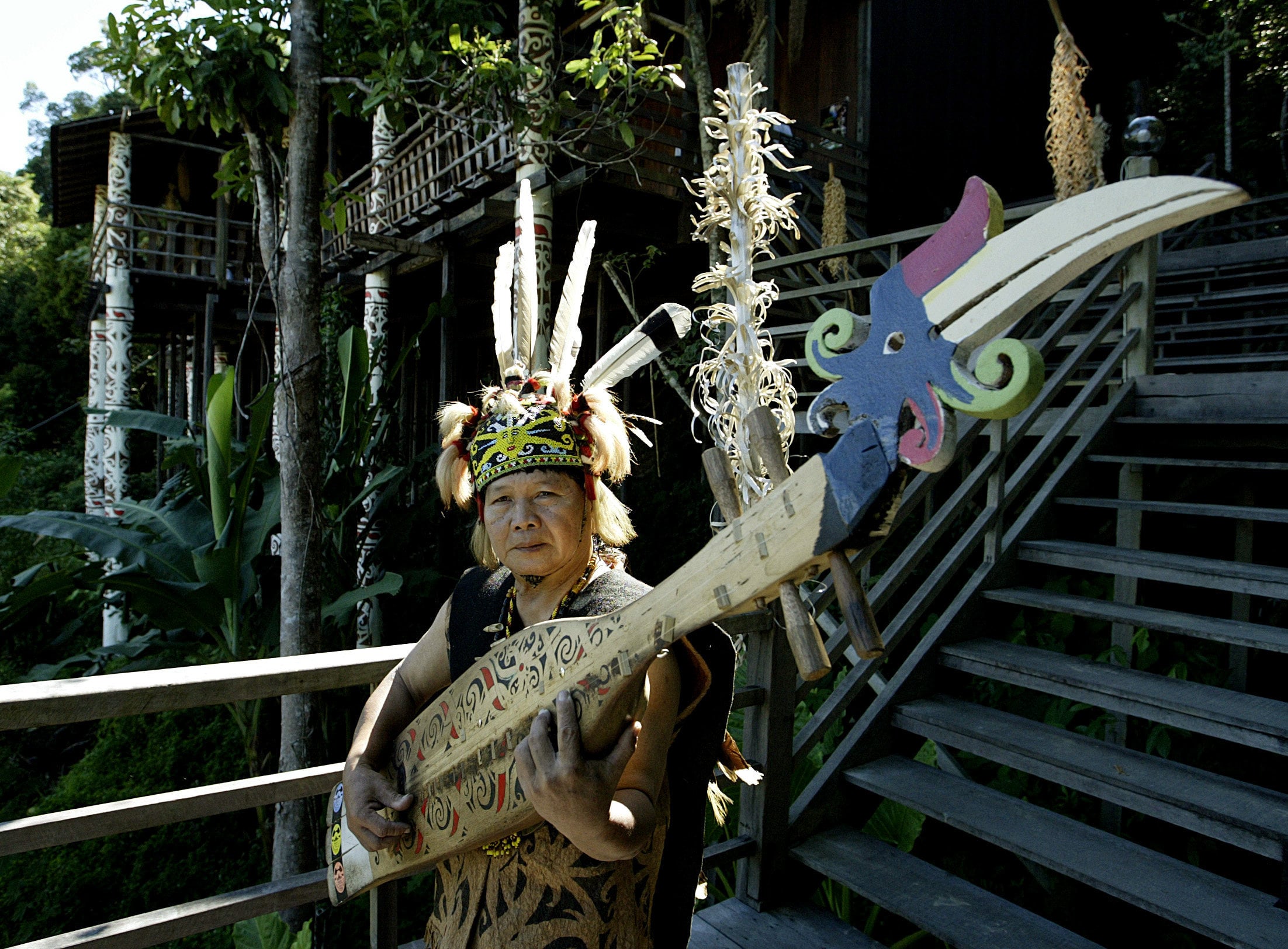 An indigenous musician plays a “sape” in front a traditional longhouse in Sarawak. Photo: Reuters