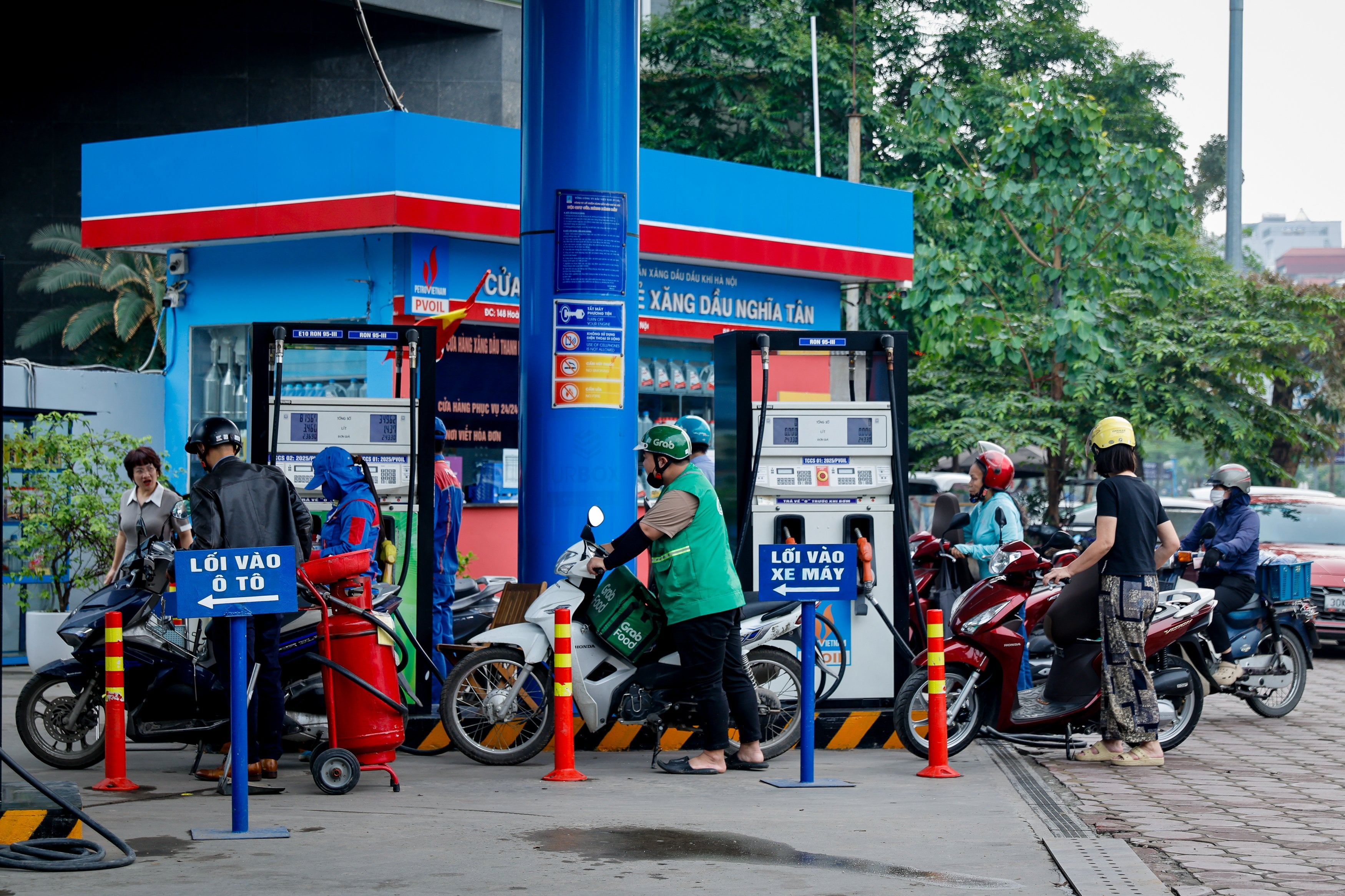 People wait to refill their motorbikes at a petrol station in Hanoi, Vietnam, on Monday. Photo: EPA